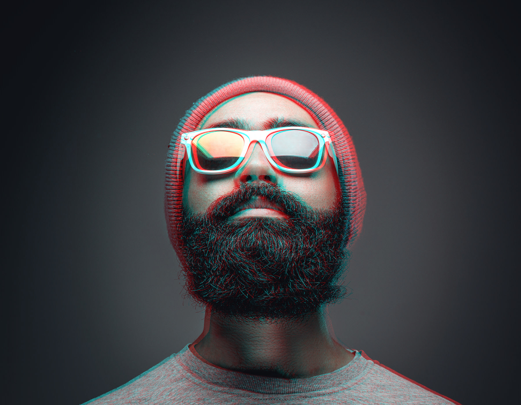 Bearded man in beanie and reflective sunglasses with glitchy 3D effect.