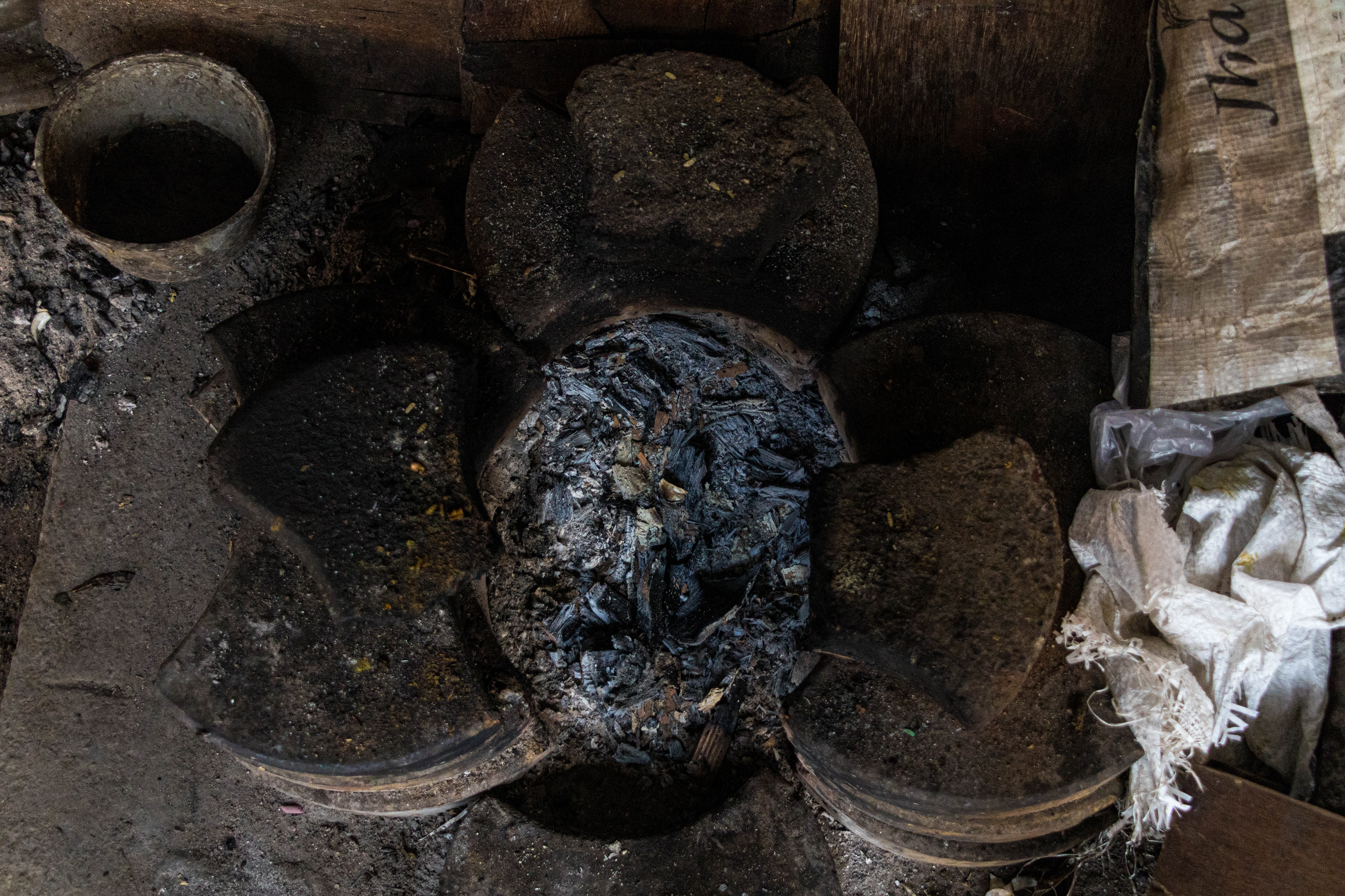 An improvised kiln for cooking made with pavement tiles. Cardboard, paper and rejected plywood is used as fuel.