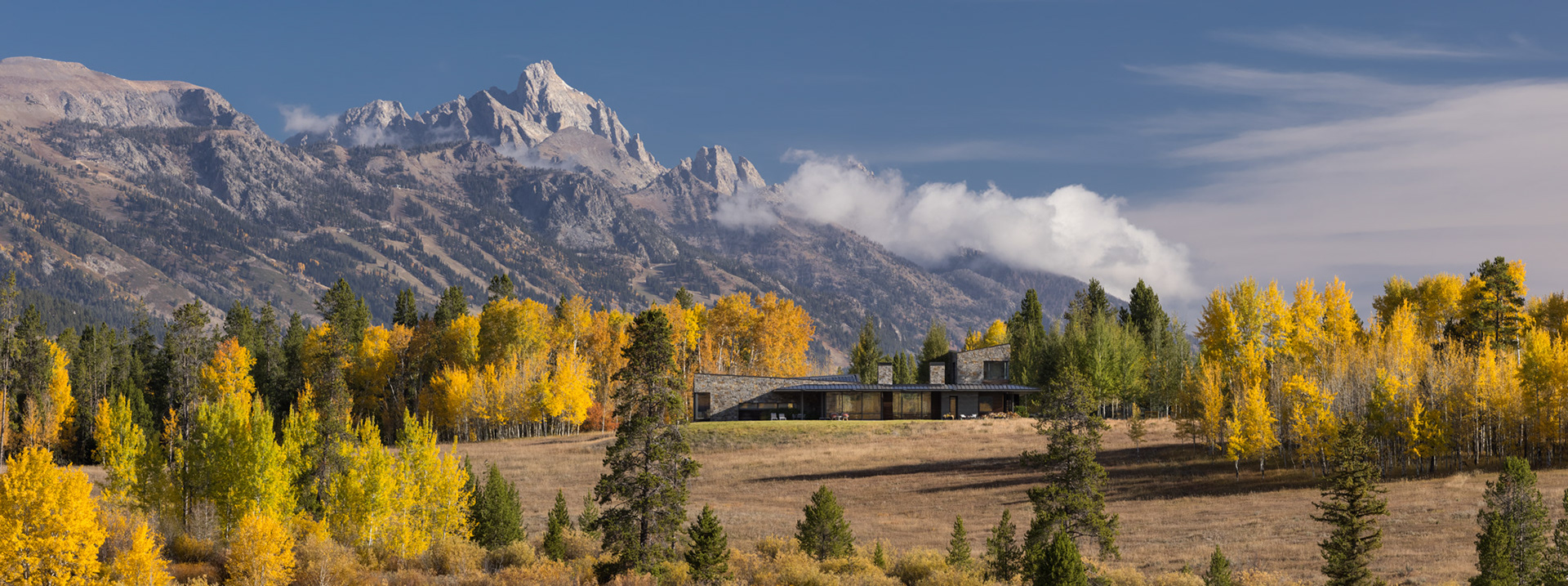 An architectural image of a CLB Architects designed home photographed during peak fall season with the Grand Teton in the background. Photograph by architectural photographer Aaron Kraft of Krafty Photos in Jackson Wyoming
