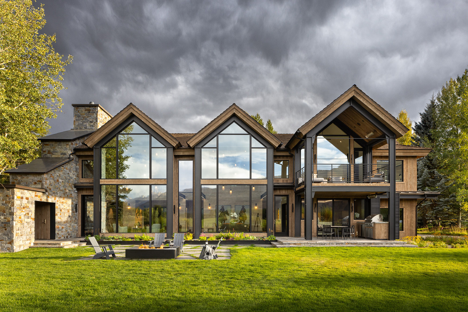 An early fall exterior image taken on a stormy evening at sunset of a remodeled home designed by architects at A43 Architecture. Photograph taken by architectural photographer Aaron Kraft of Krafty Photos based out of Jackson Hole Wyoming.