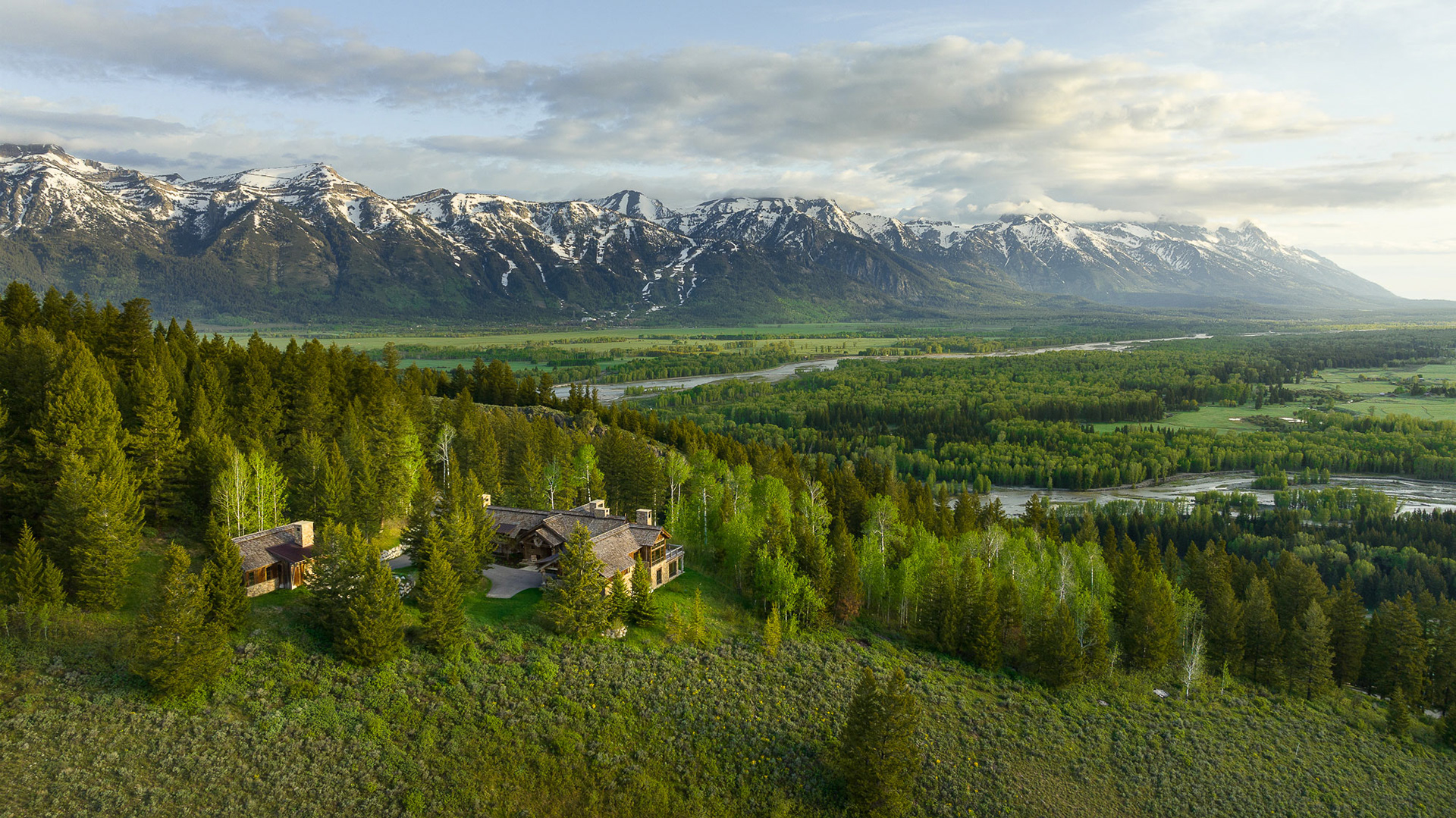 early morning aerial photograph of a Berlin Architects project photographed in early spring overlooking the Snake River and the Teton mountain range. Photograph by architectural photographer Aaron Kraft of Krafty Photos in Jackson hole wyoming