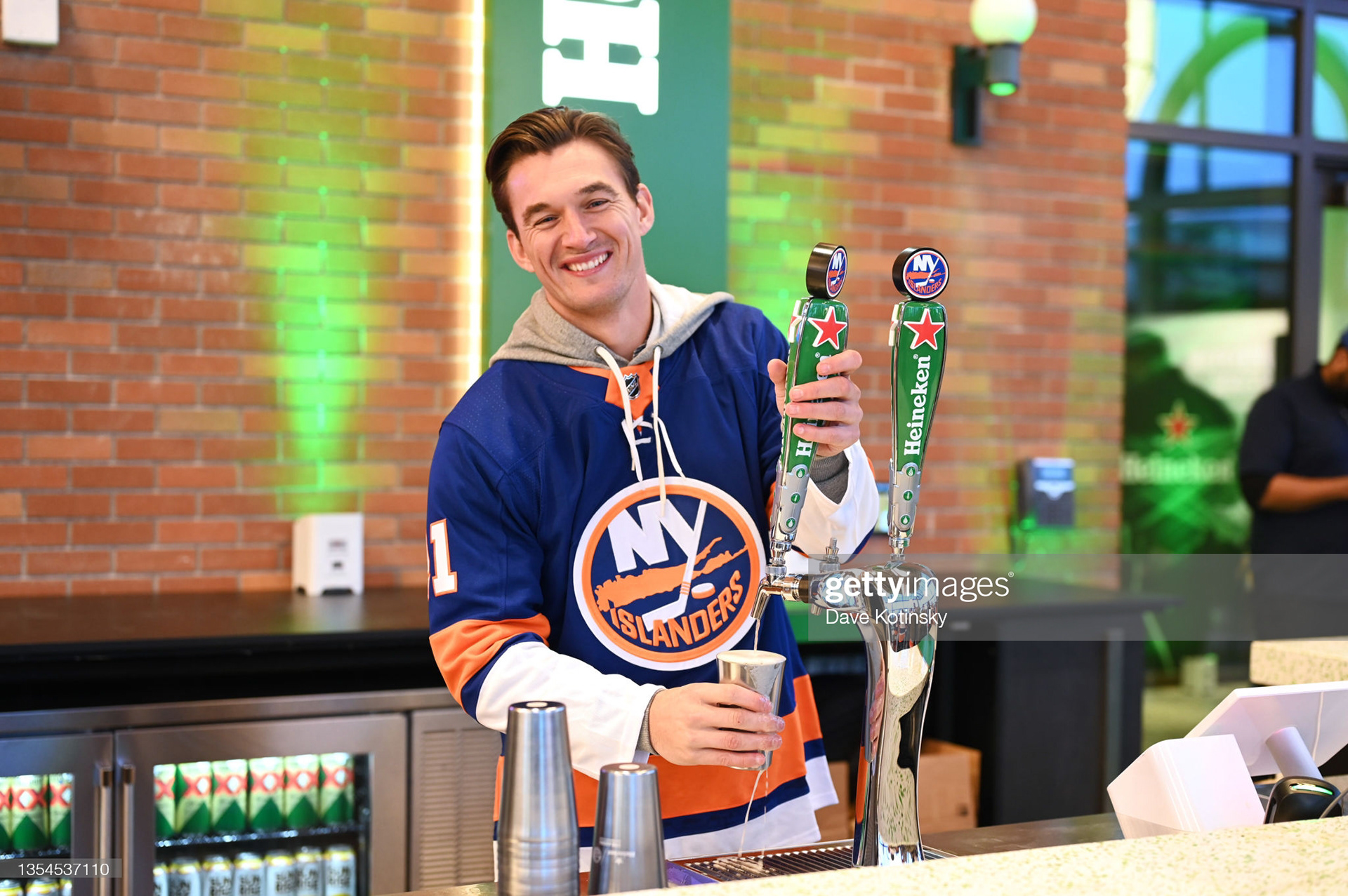 Tyler Cameron serves a Heineken to New York Islanders fans at the Heineken Terrace Bar at the UBS Arena in Elmont, NY on November 20, 2021. (Photo by Dave Kotinsky/Getty Images for Heineken)