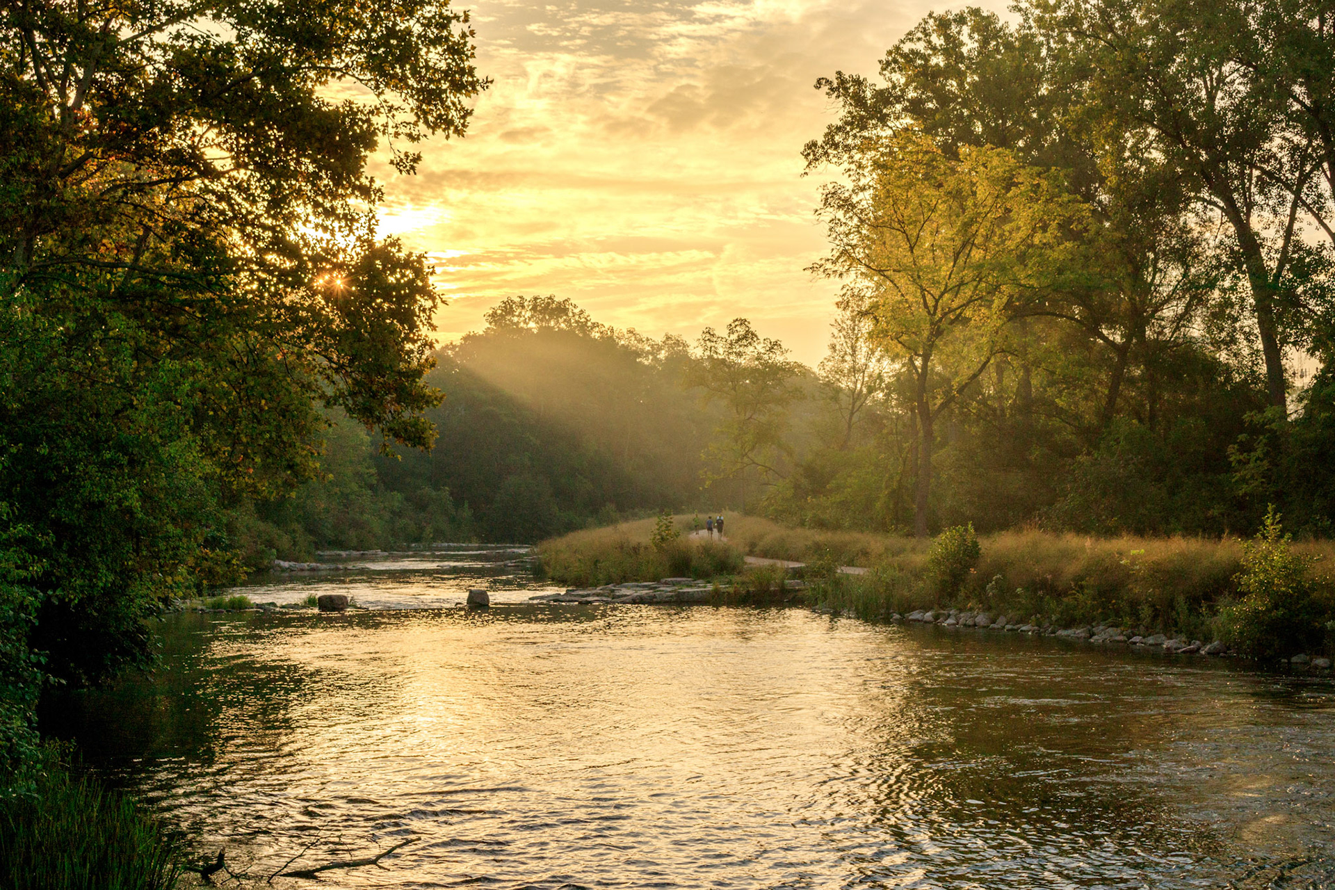 Morning sunbeams on the Huron River at the Argo Cascades, Ann Arbor, Michigan