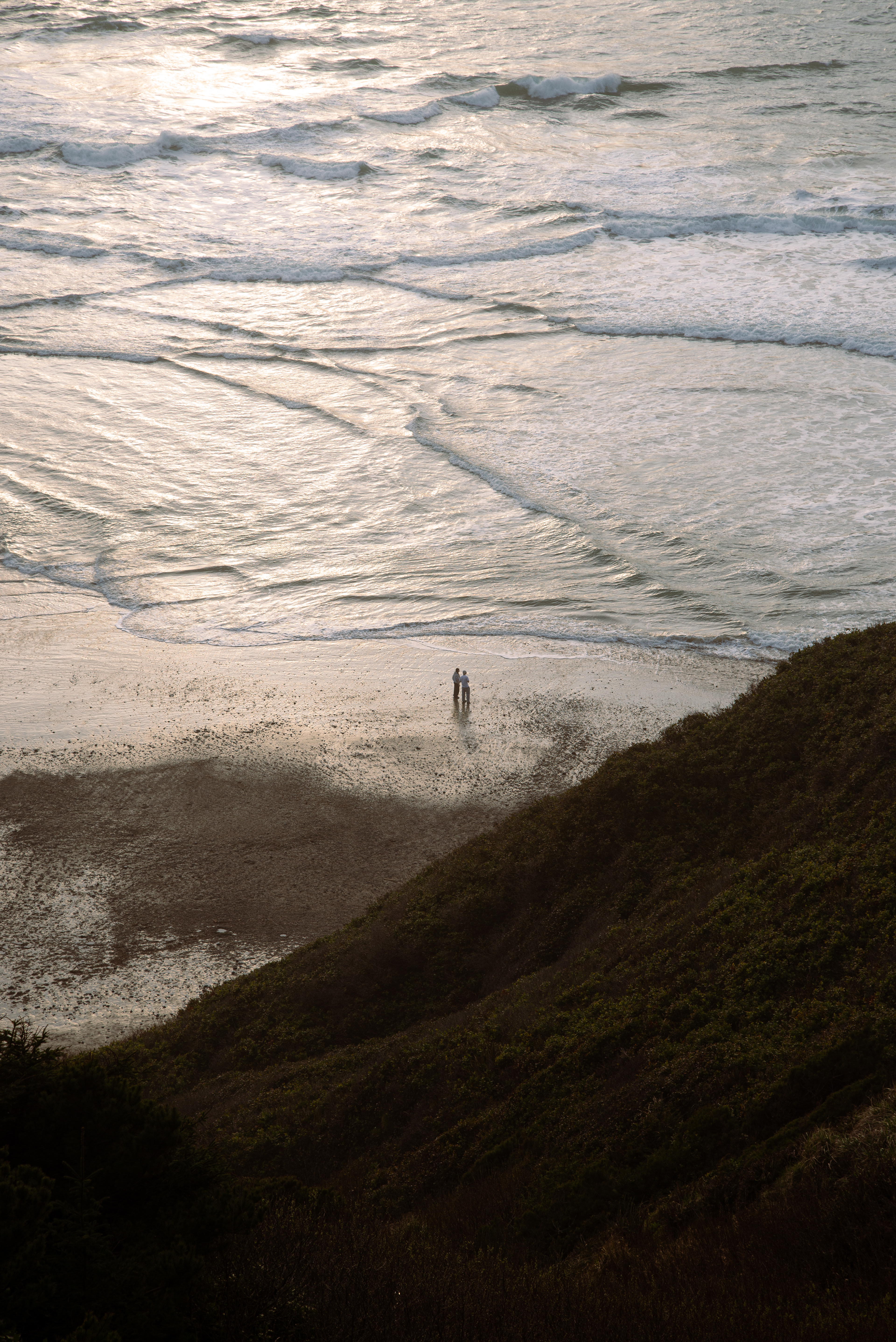 Two people stroll along a section of the beach in Oceanside, OR