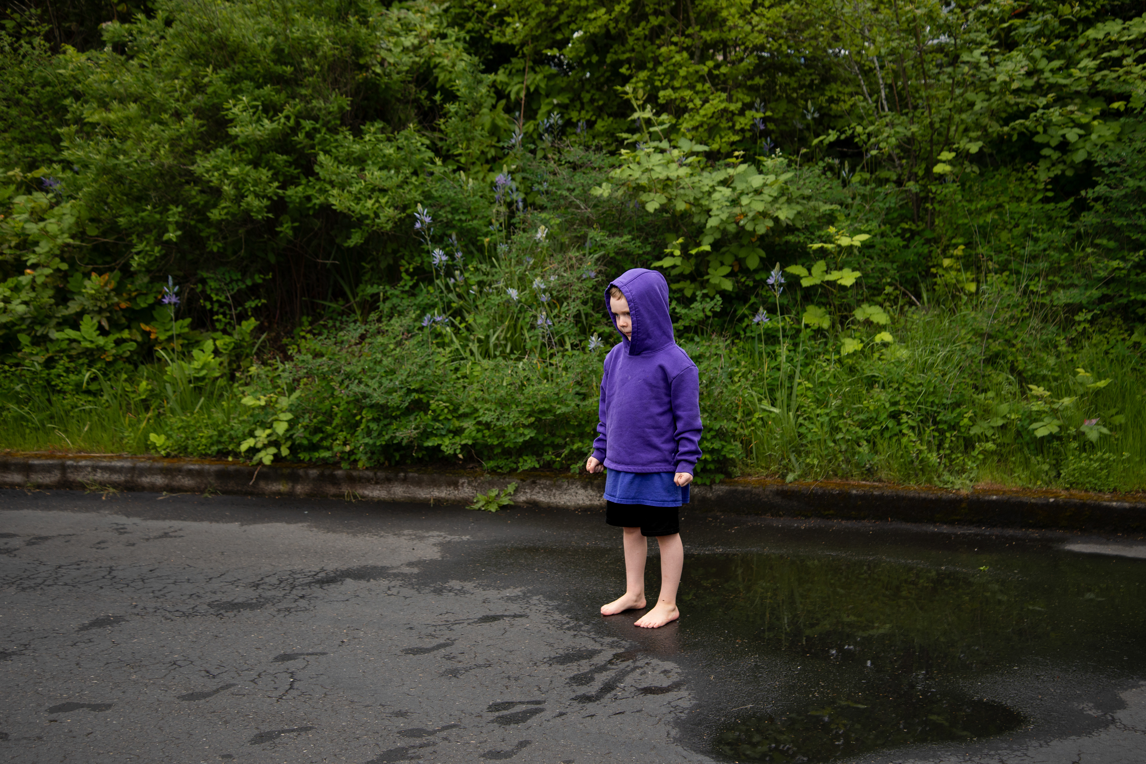 A boy plays in a puddle at a Portland farmers market