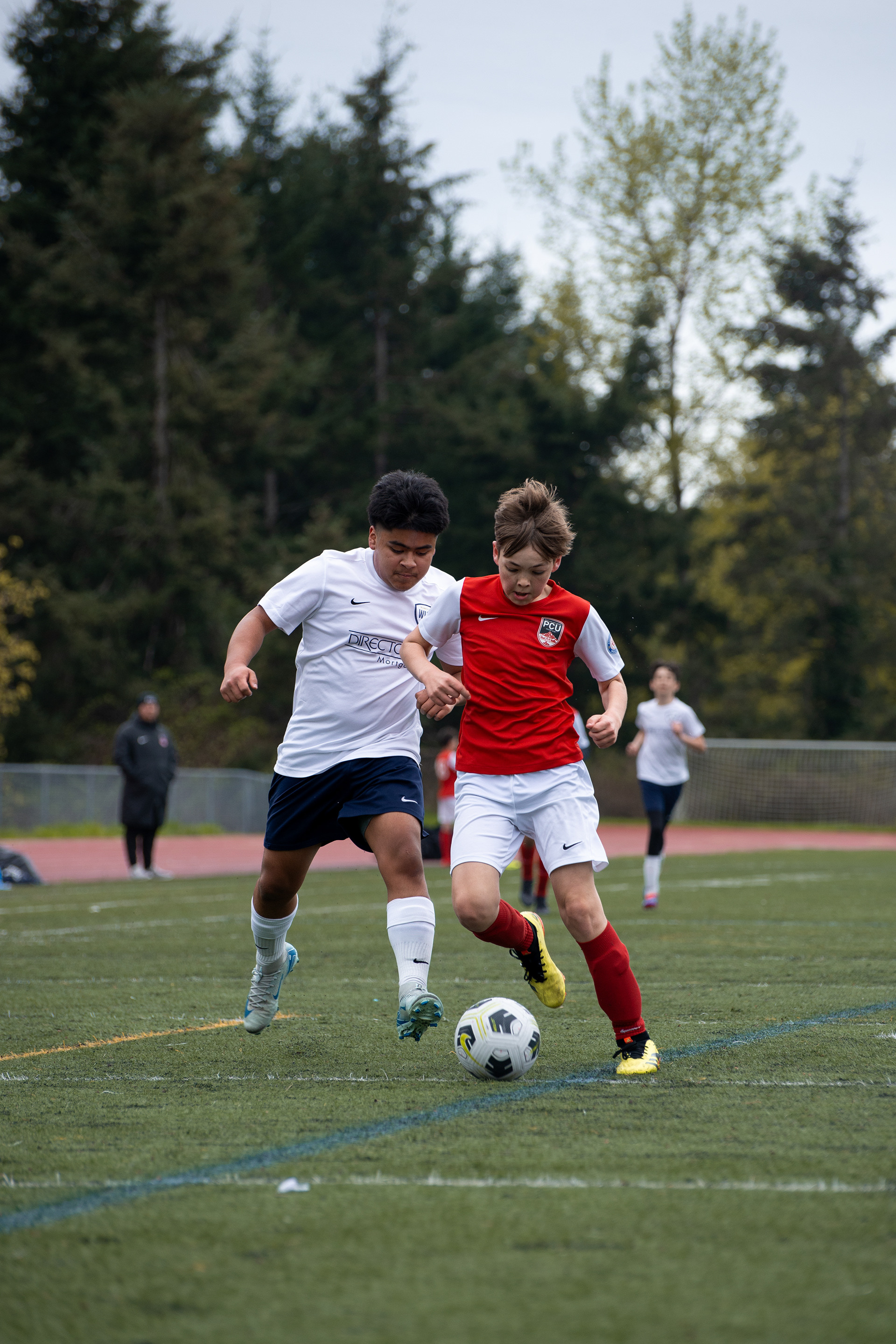 Two soccer players compete for a ball