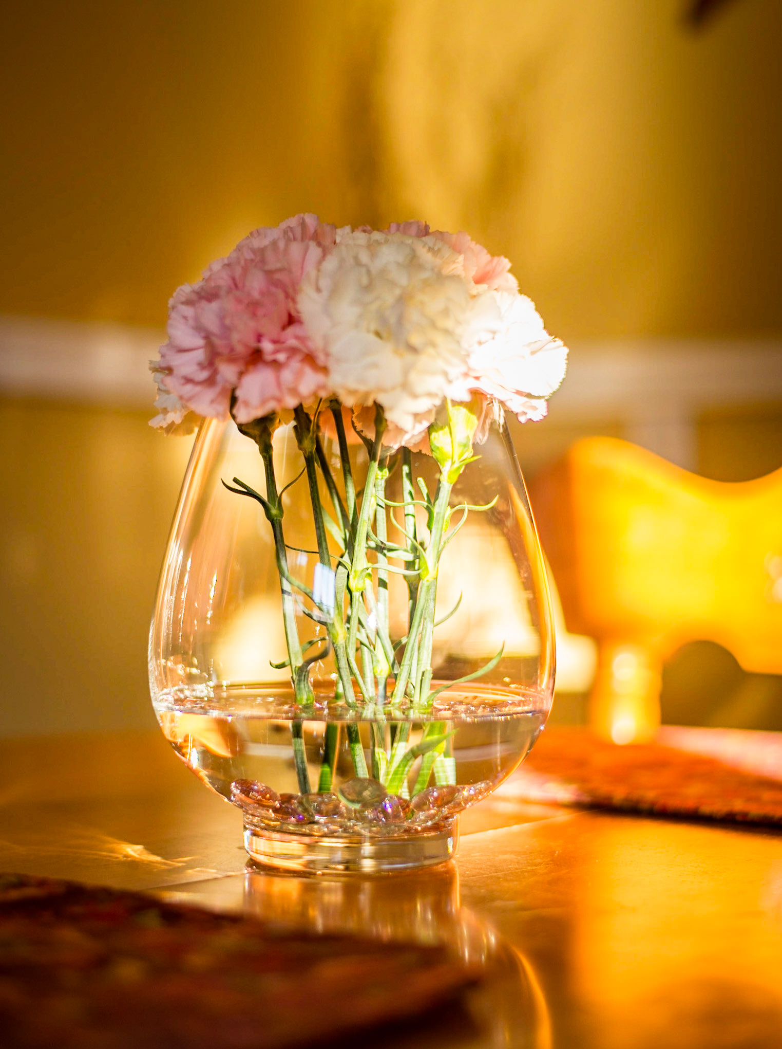 Light splashing on a vase of fresh cut flowers on a kitchen table