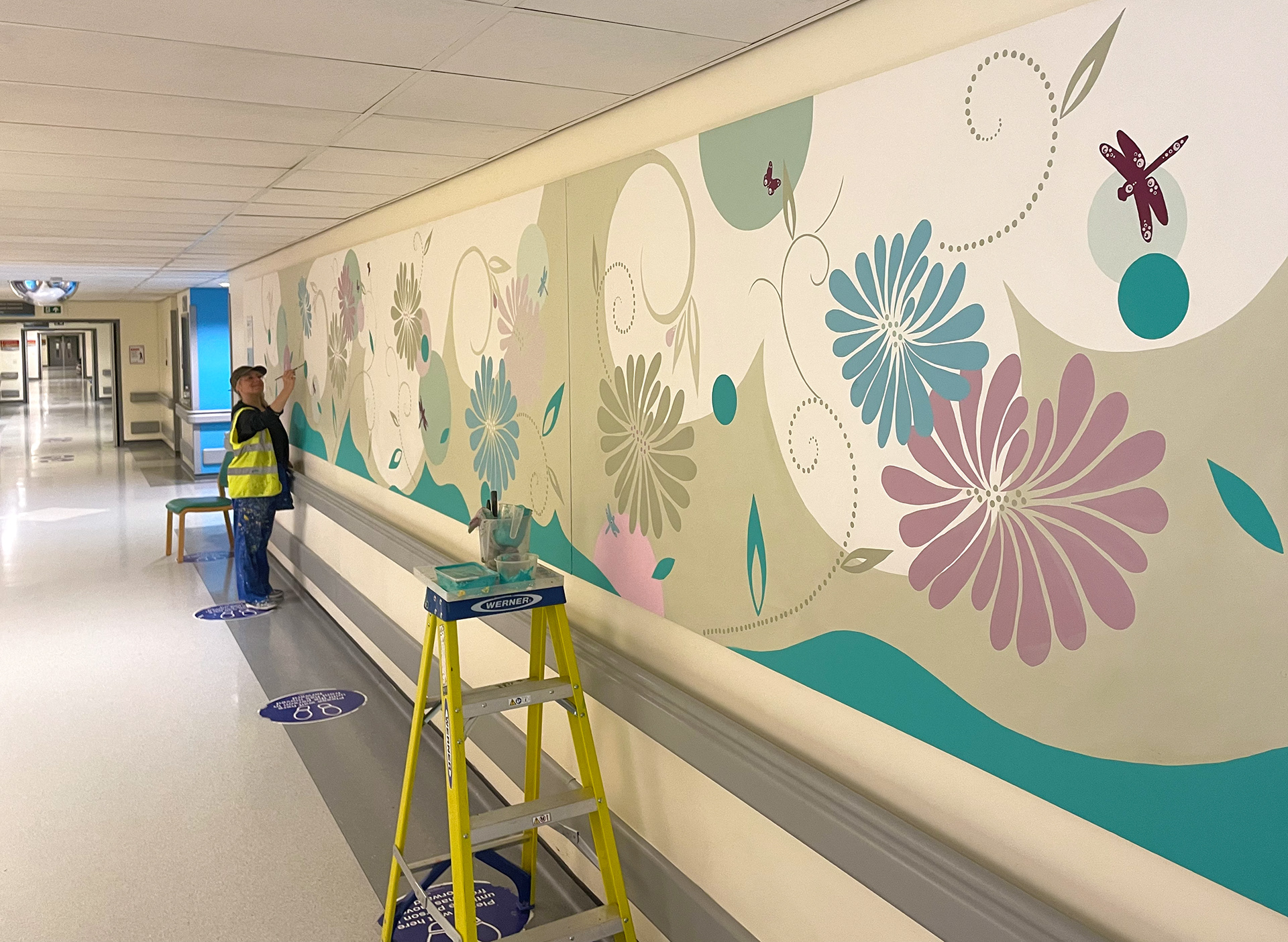 Lynne painting corridor at Royal Derby Hospital