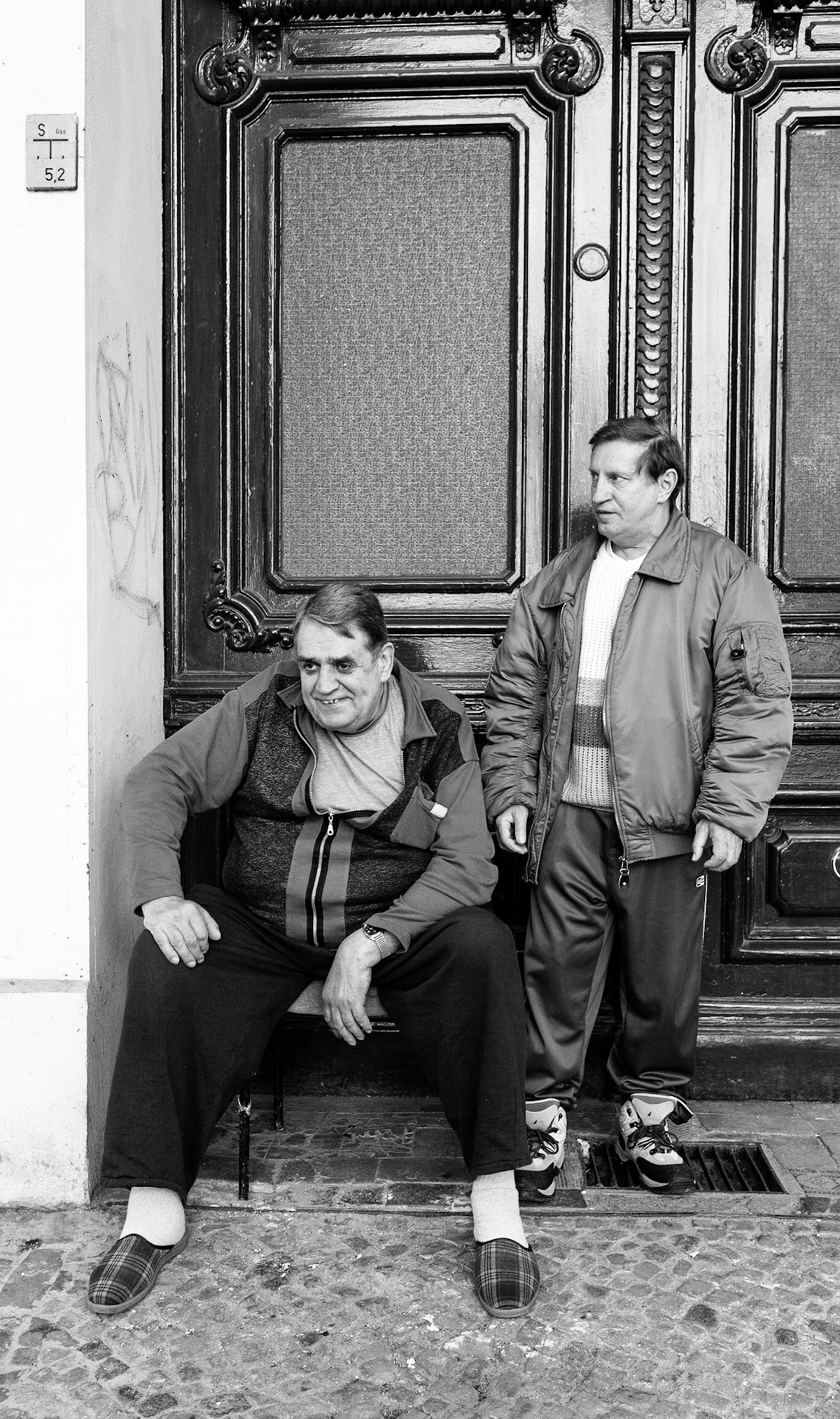 Zwei M‰nner verbringen den sonnigen Fr¸hjahrsnachmittag am Rand der Urbanstrafle in Berlin-Kreuzberg. Two men spending their time on the pavement in Berlin-Kreuzberg, Germany, 2007.