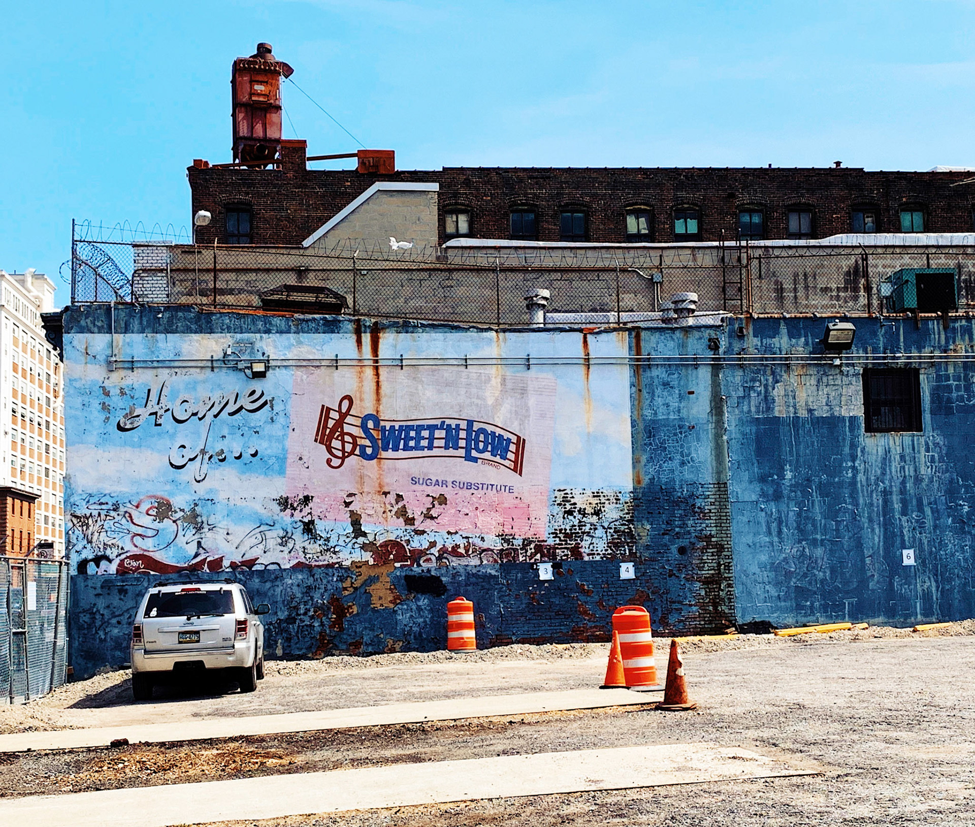 Vehicle parked in front of a wall with faded advertisement painting, Brooklyn, New York City, USA
