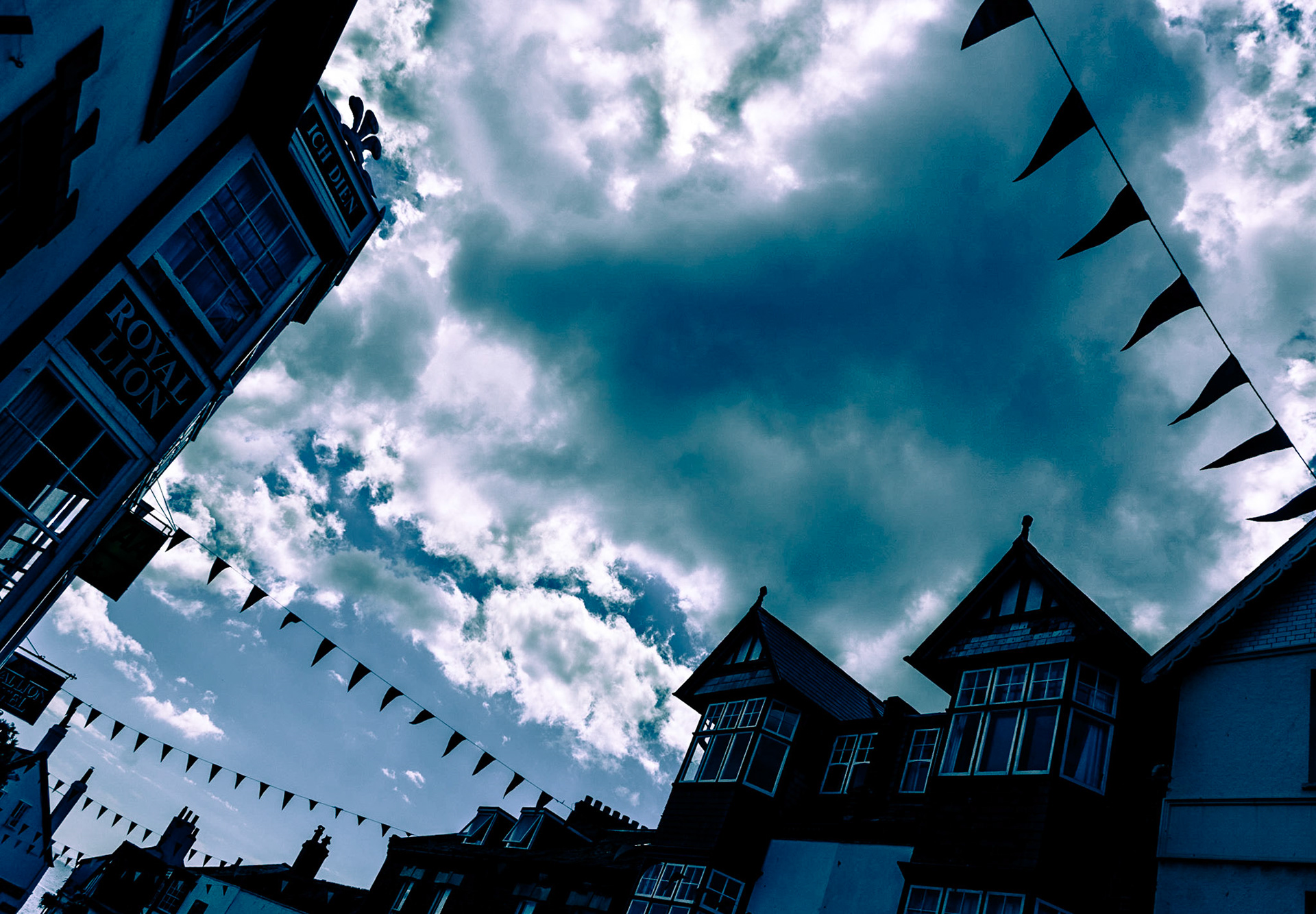 Regenwolken über der festlich geschmückten BRIDGE STREET in der britischen Küstenstadt LYME REGIS.