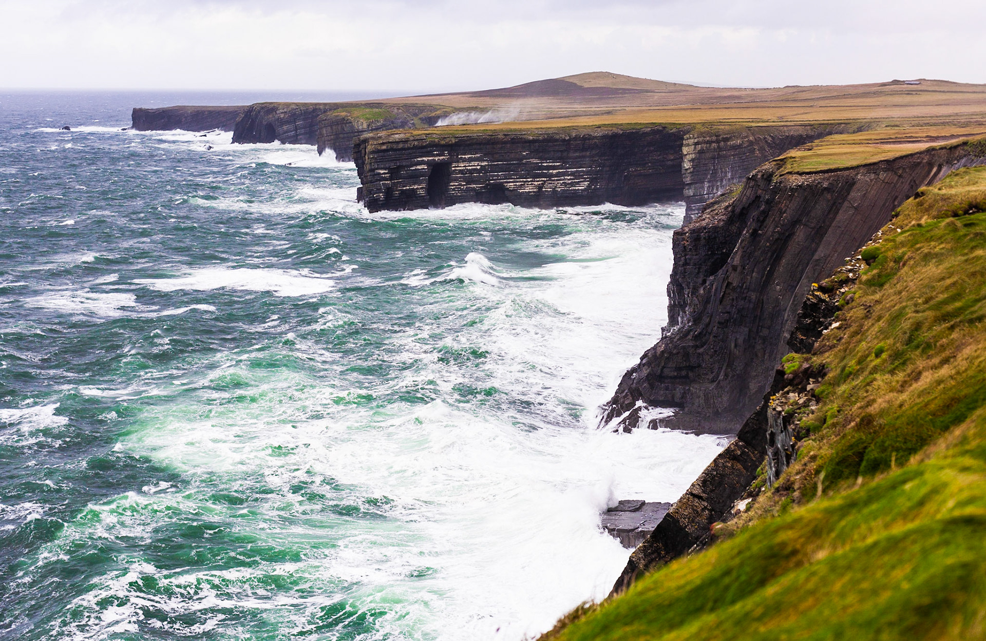 Meeresbrandung an den dem atlantischen Ozean zugewandten Klippen des Loop Head in der irischen County Clare.