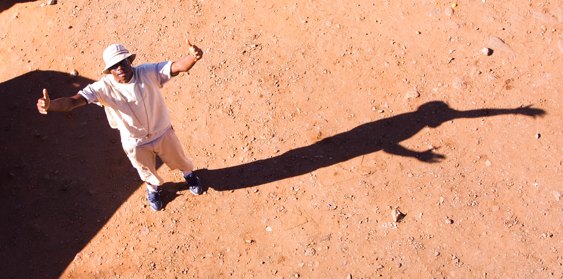 An ihabitant gestures towards the photographer, Soweto, South Africa, 2003.