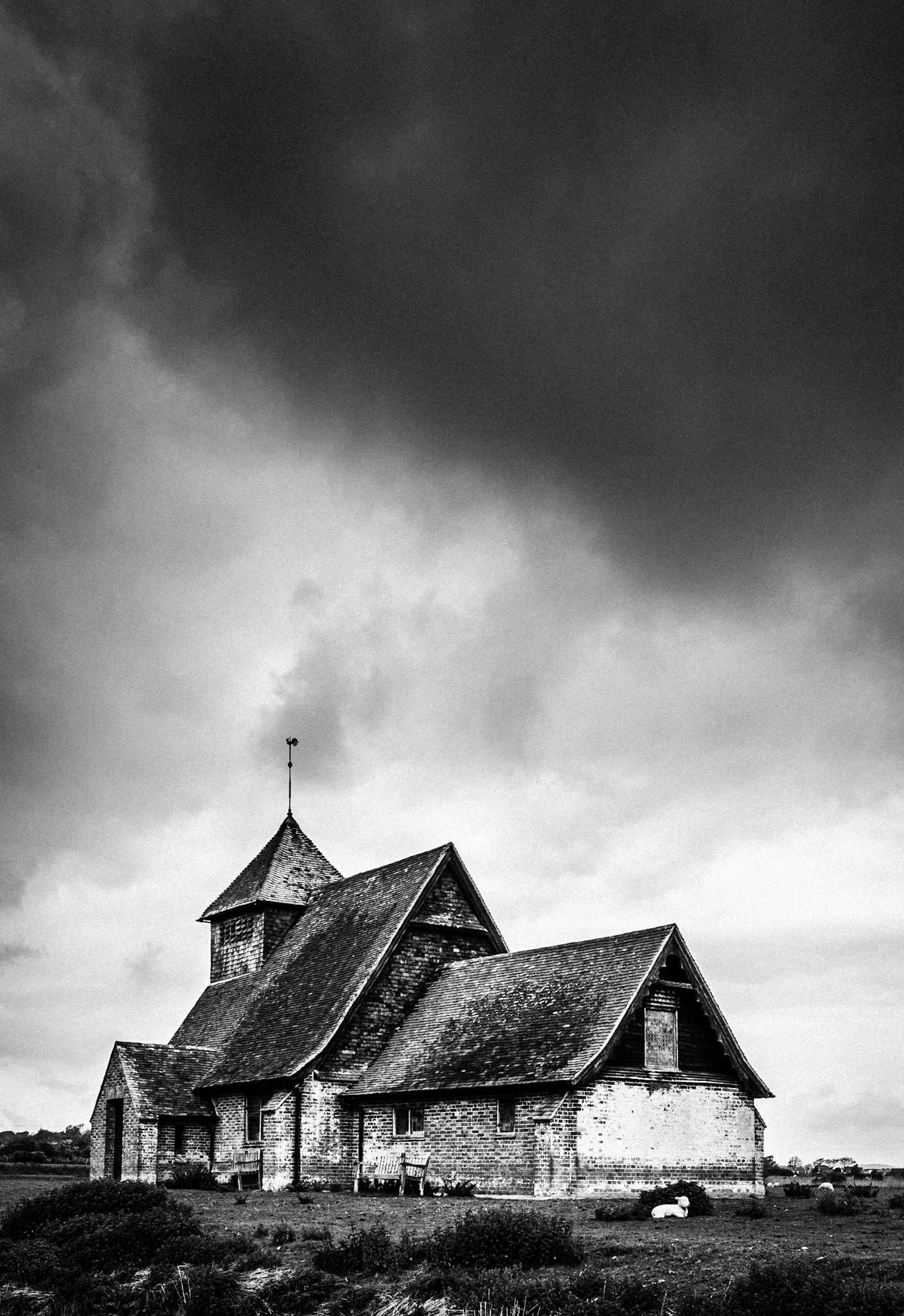Dunkle Wolken über alter Kapelle St Thomas Becket, Fairfield, Romney Marsh, Großbritannien