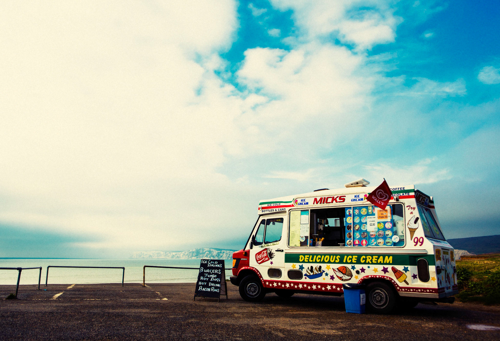 Ein Eis- bzw. Verkaufswagen steht auf einem Küstenparkplatz oberhalb der Compton Bay auf der Isle of Wight, Großbritannien.