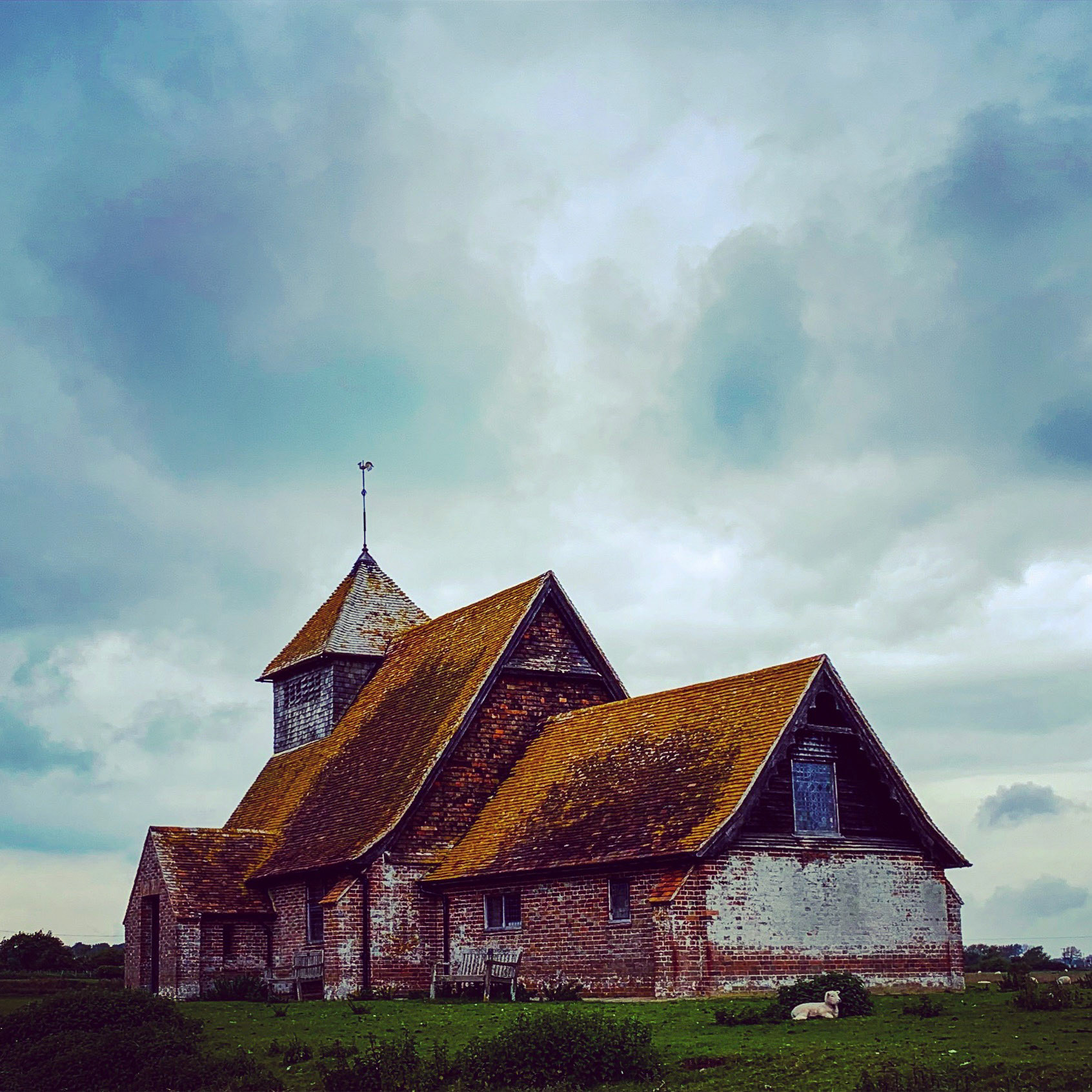 Dunkle Wolken über alter Kapelle St Thomas Becket, Fairfield, Romney Marsh, Großbritannien
