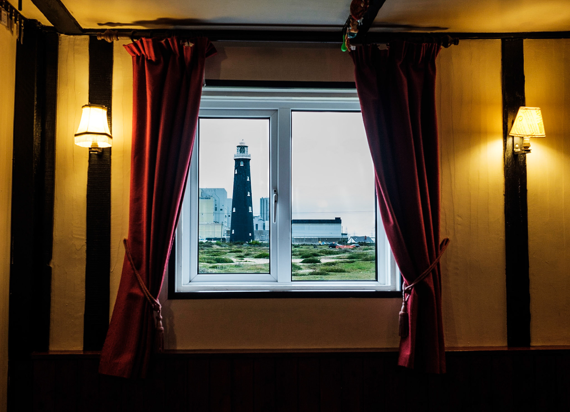 Leuchtturm „The Old Lighthouse“, gesehen durch das Fenster des „Britannia Inn“, Pub in der Romney Marsh. Dungeness, Kent, England, Großbritannien.