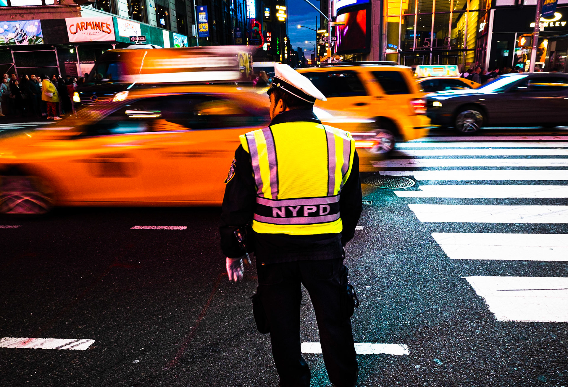 Polizist mit NYPD-Warnweste überwacht den starken Taxiverkehr am Times Square, Manhattan, New York City, USA