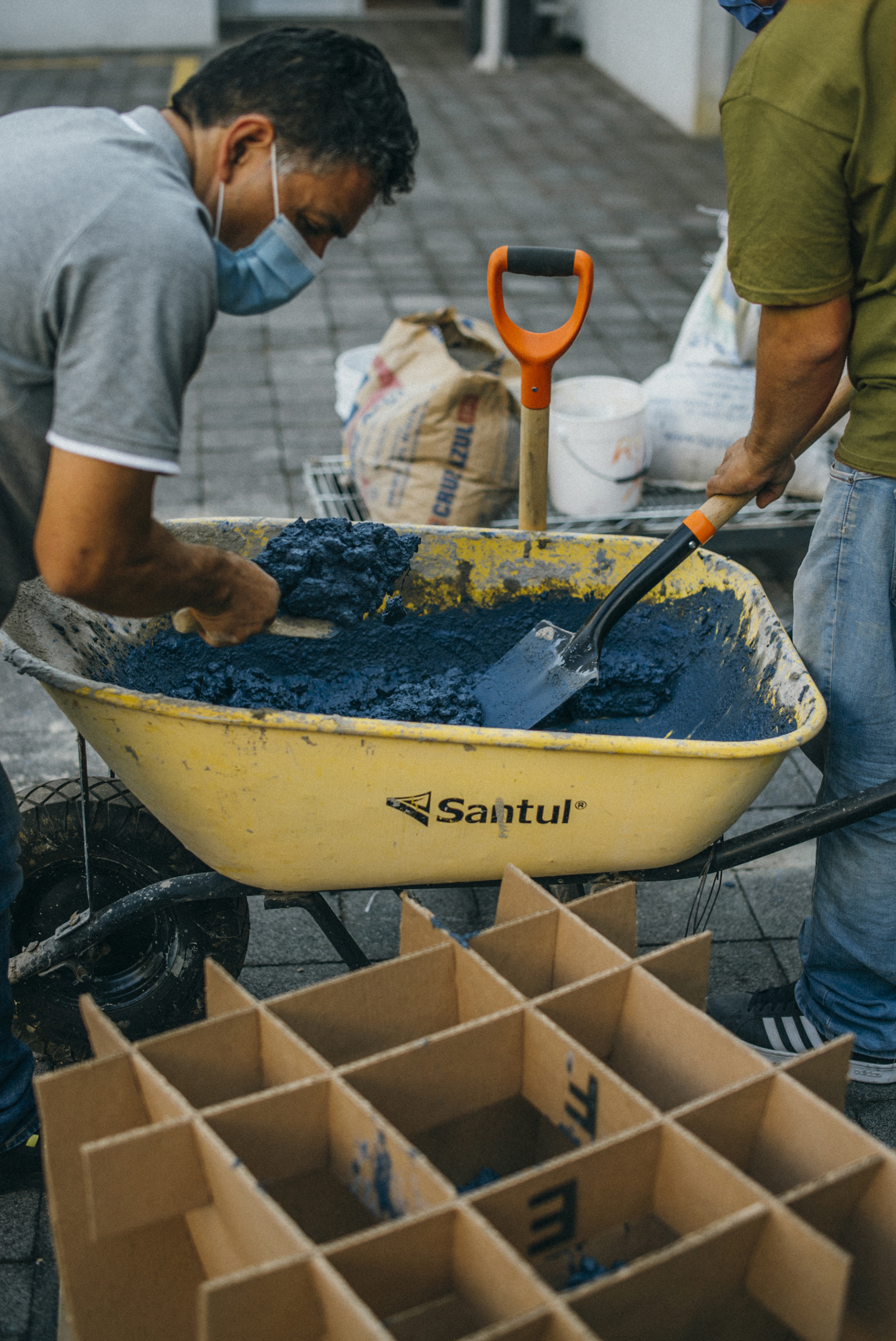 6 - The concrete mix is carefully poured into the mold, filling it to the brim, and finally the QR plaque is placed.