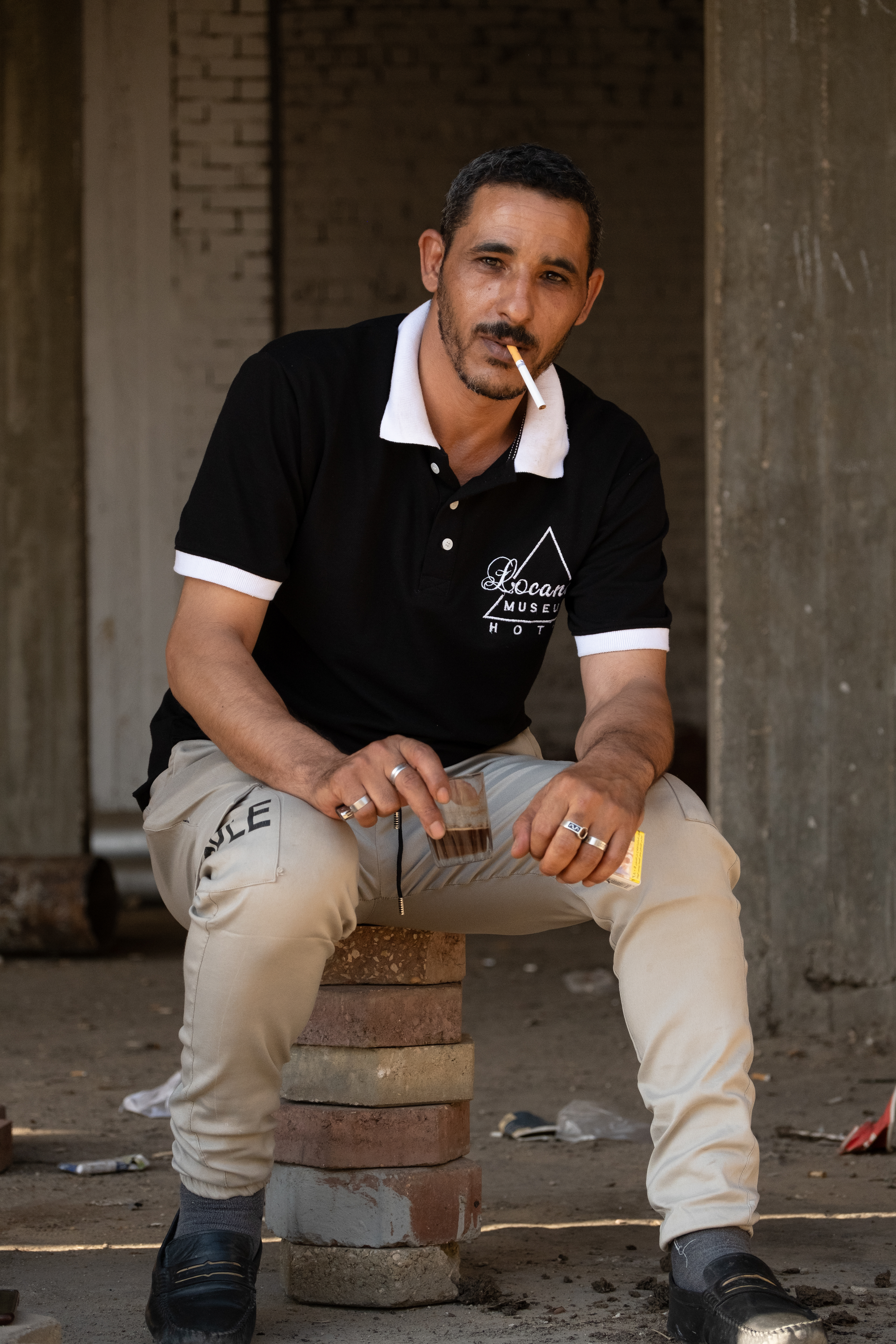 Hotel doorman takes a coffee and cig break. Giza, Egypt.
