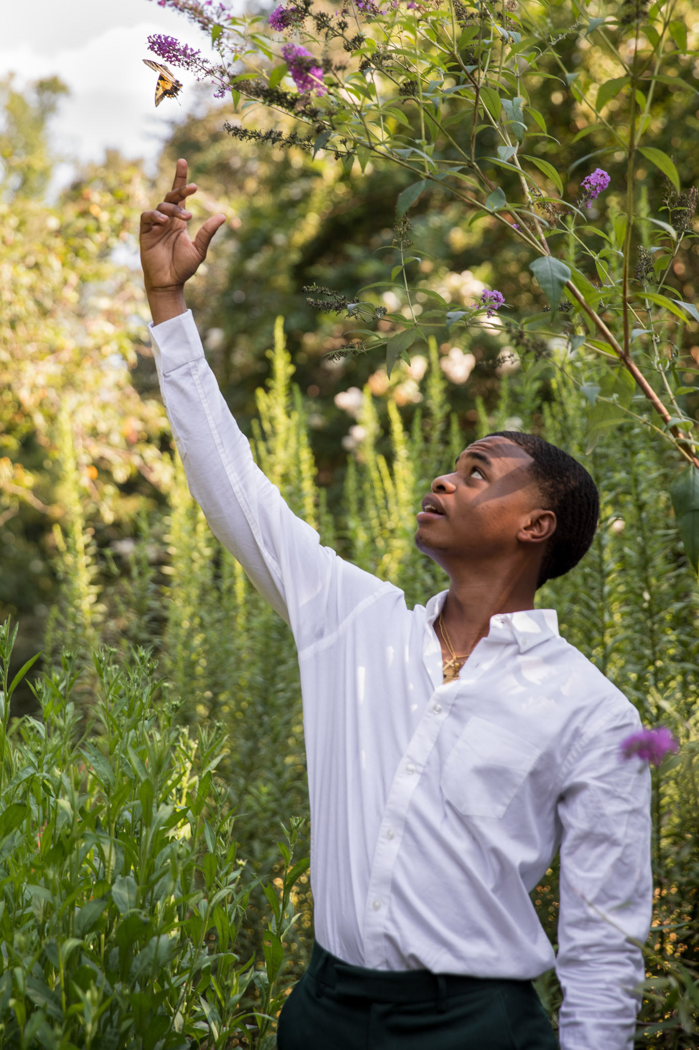 Khwezi Nxasana reaches for butterfly during a portrait shoot at the Tanger Family Bicentennial Garden in Greensboro, N.C., on August 26, 2020 