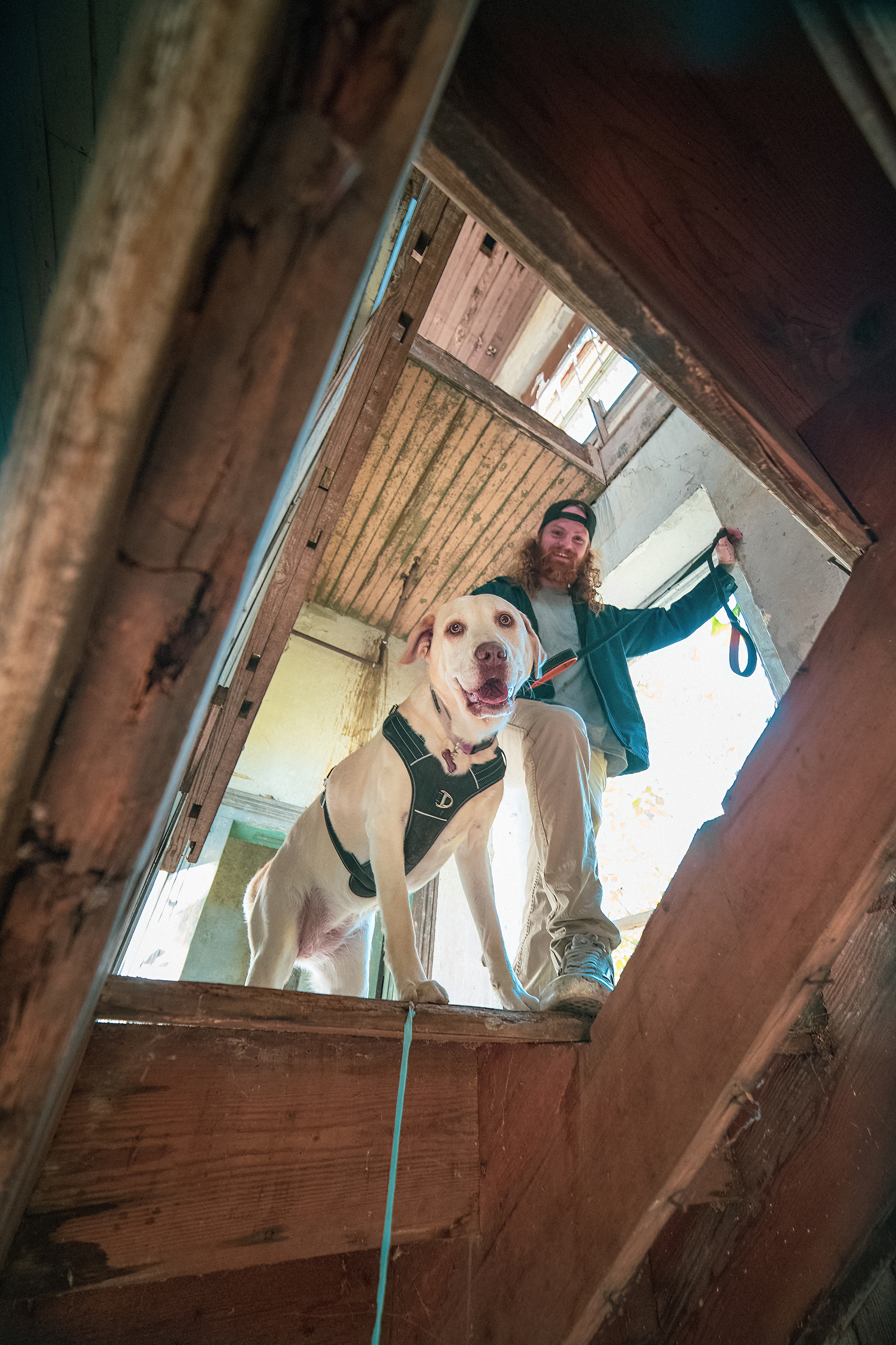 Casey Franks (posed) stands with his dog, Turbo,  in a old house in Randleman, N.C. on October 21, 2022. 