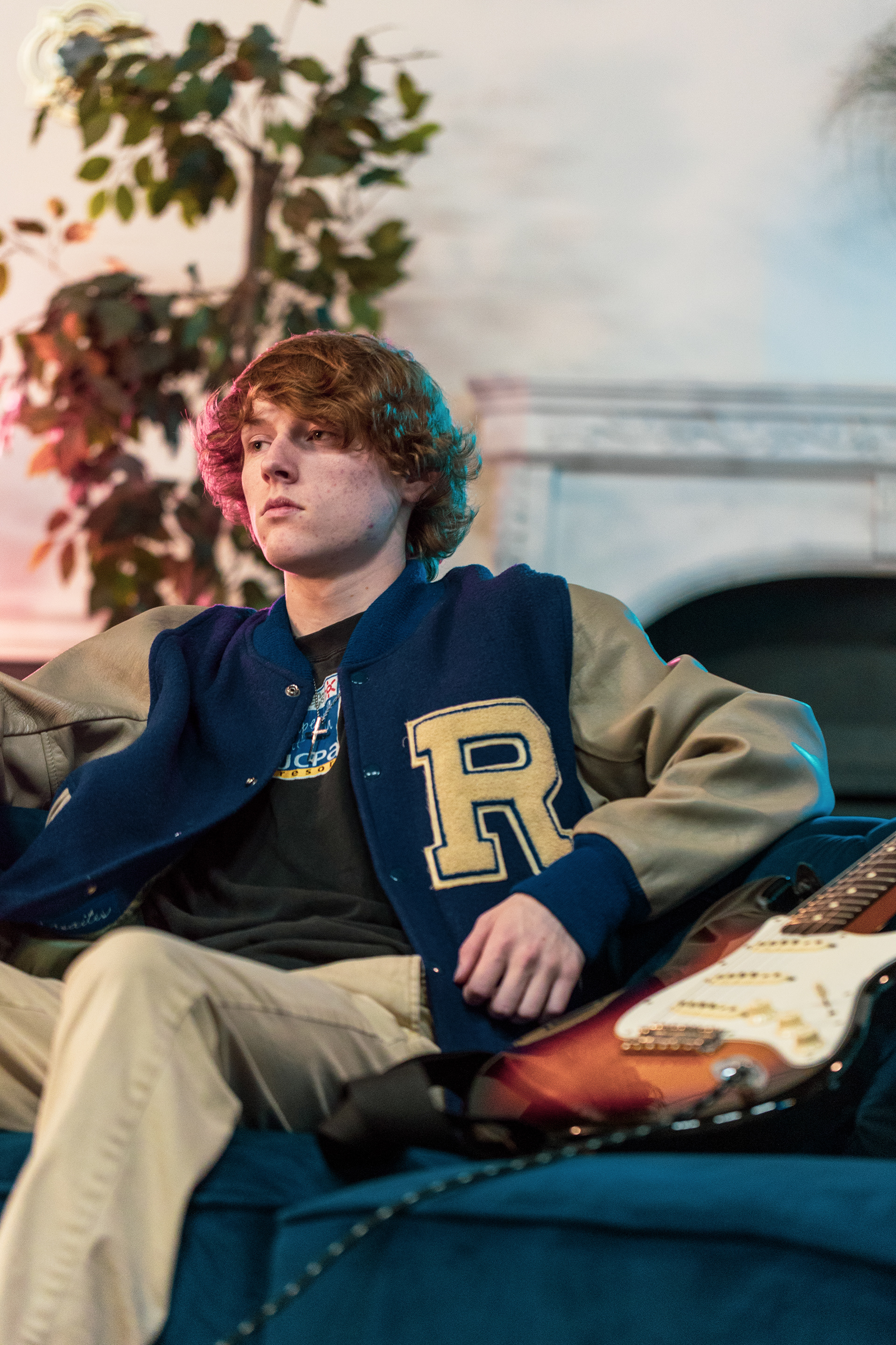 Holden Kayhko (posed) sits with his guitar on a couch at Hardpress Studios in Greensboro, N.C. on April 6th, 2022 