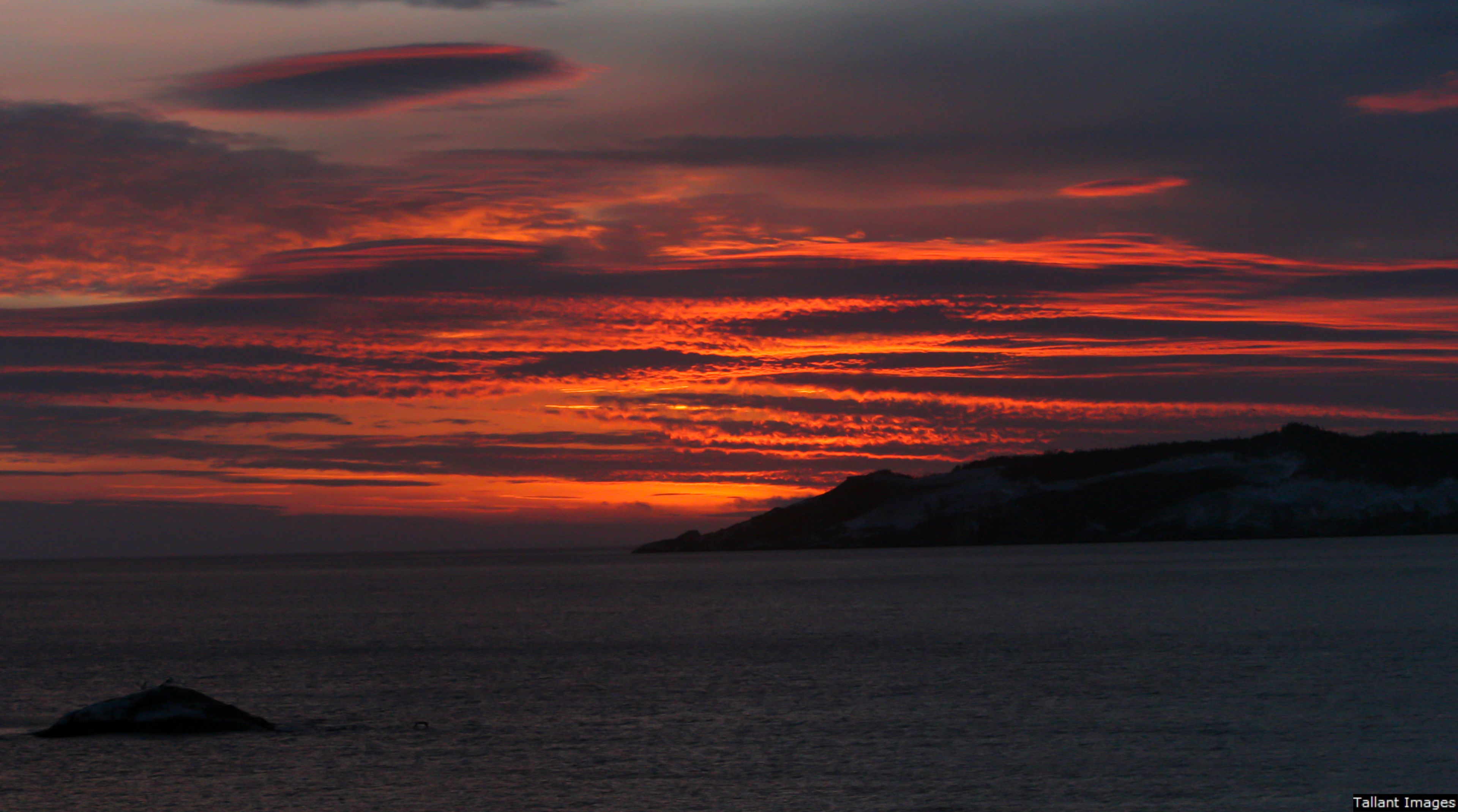 Warm Sky, Icy Ocean Water, Frozen Island Landscape