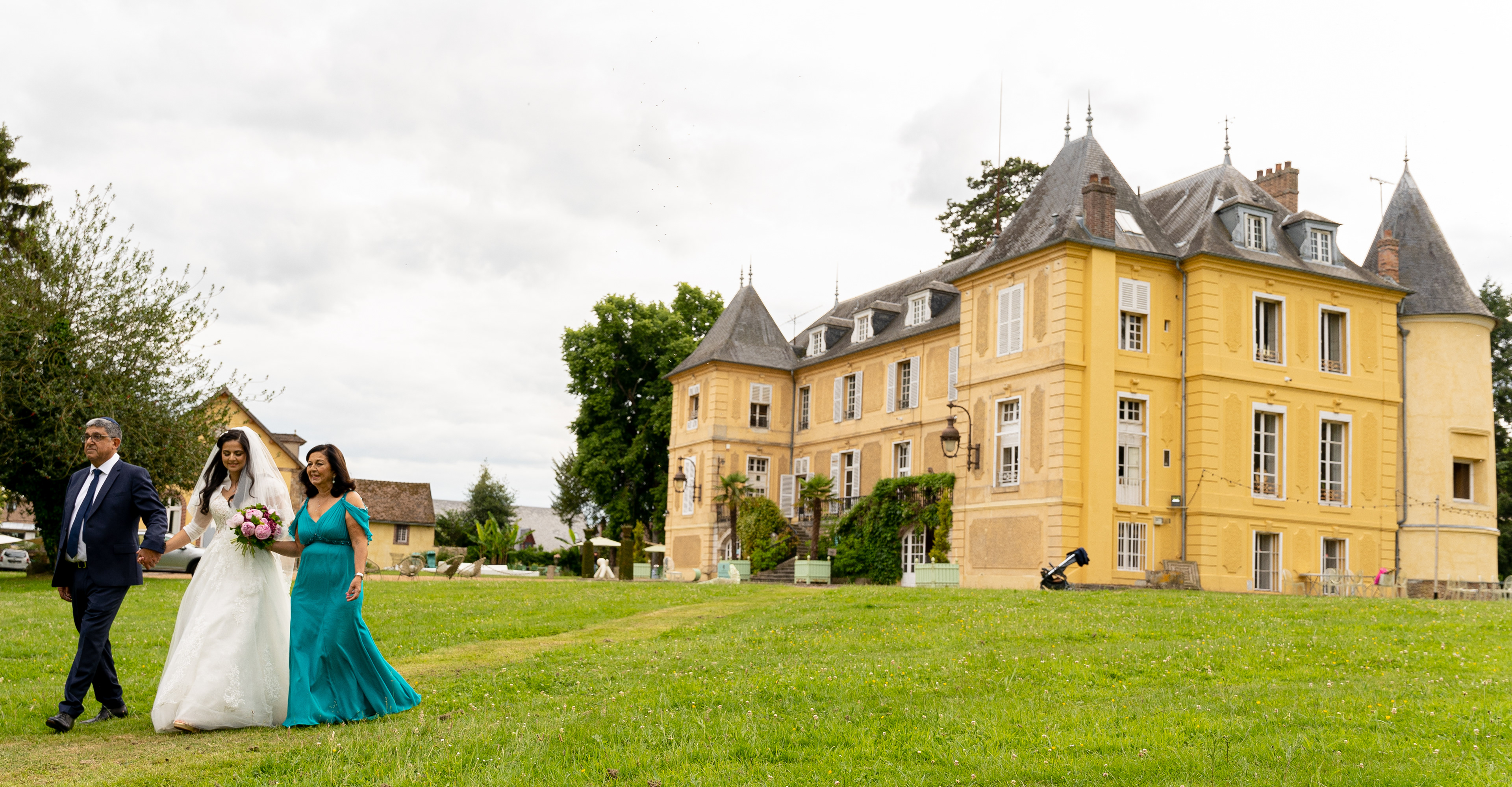 La mariée arrive à la cérémonie accompagnée de ses parents