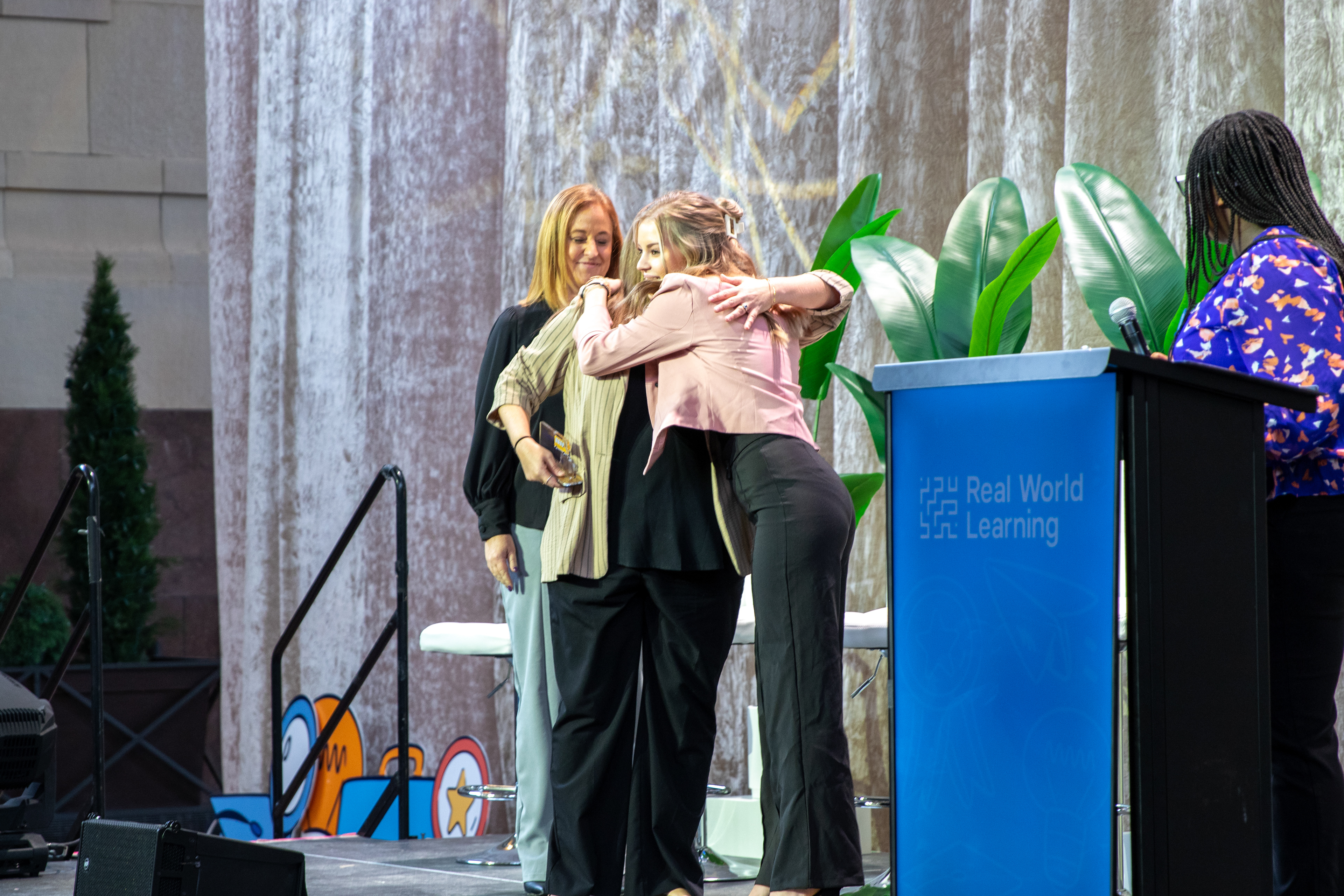Mackenzey Spiller embraces Pedagogy Pioneers winners Sarah Renfrow and Stefani Russ, both of whom are from her own high school, Raymore Peculiar. 