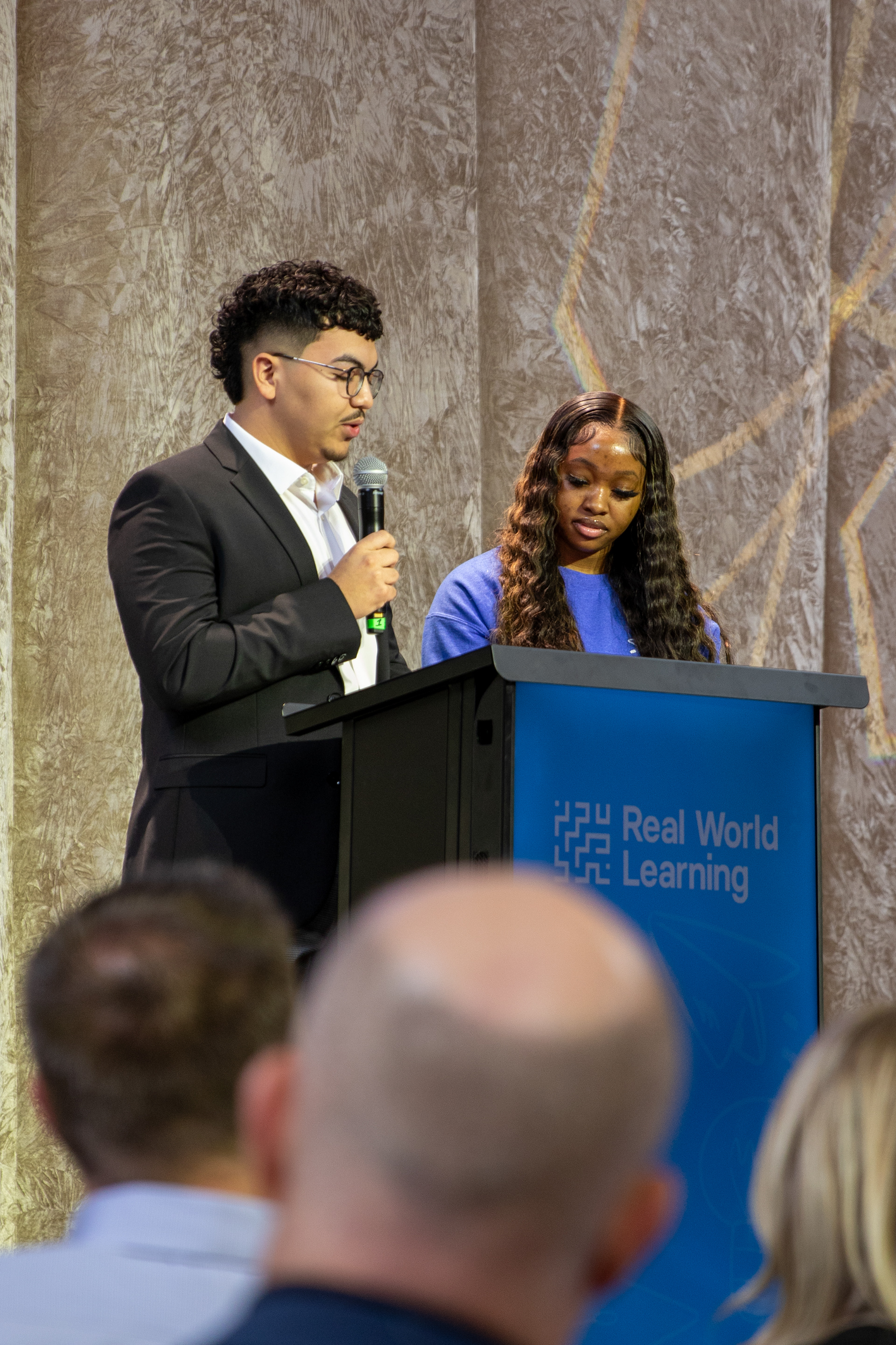 Mariah Presley-Robinson, Grandview High School student, and Miguel Tapia Becerra, Shawnee Mission North student, take the stage to begin the event. 