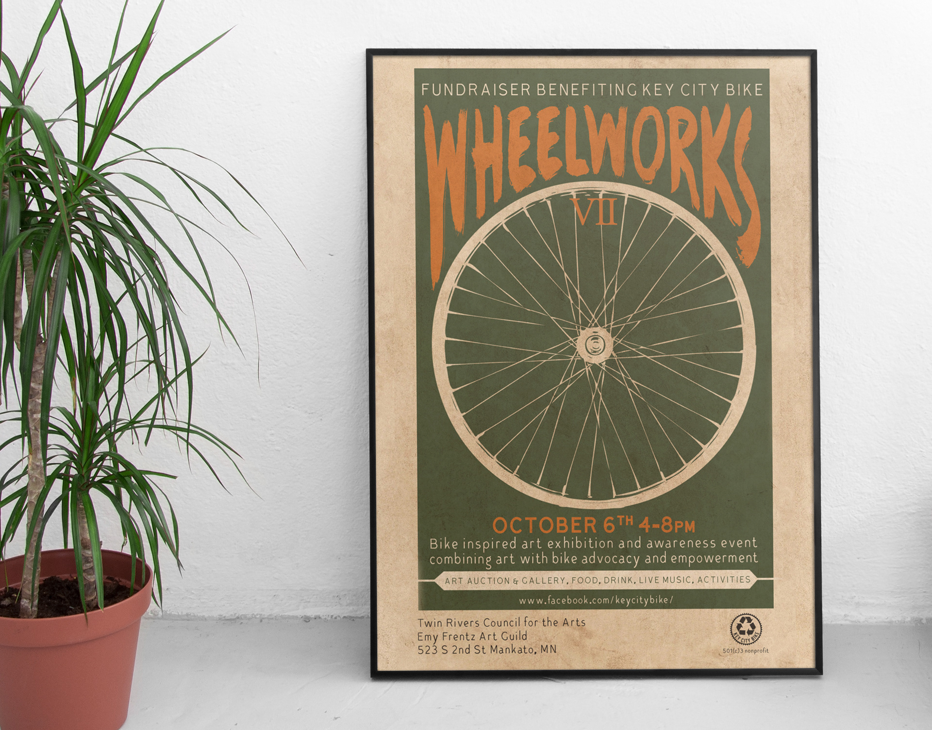 wheelworks event poster for Key City Bike sitting next to houseplant