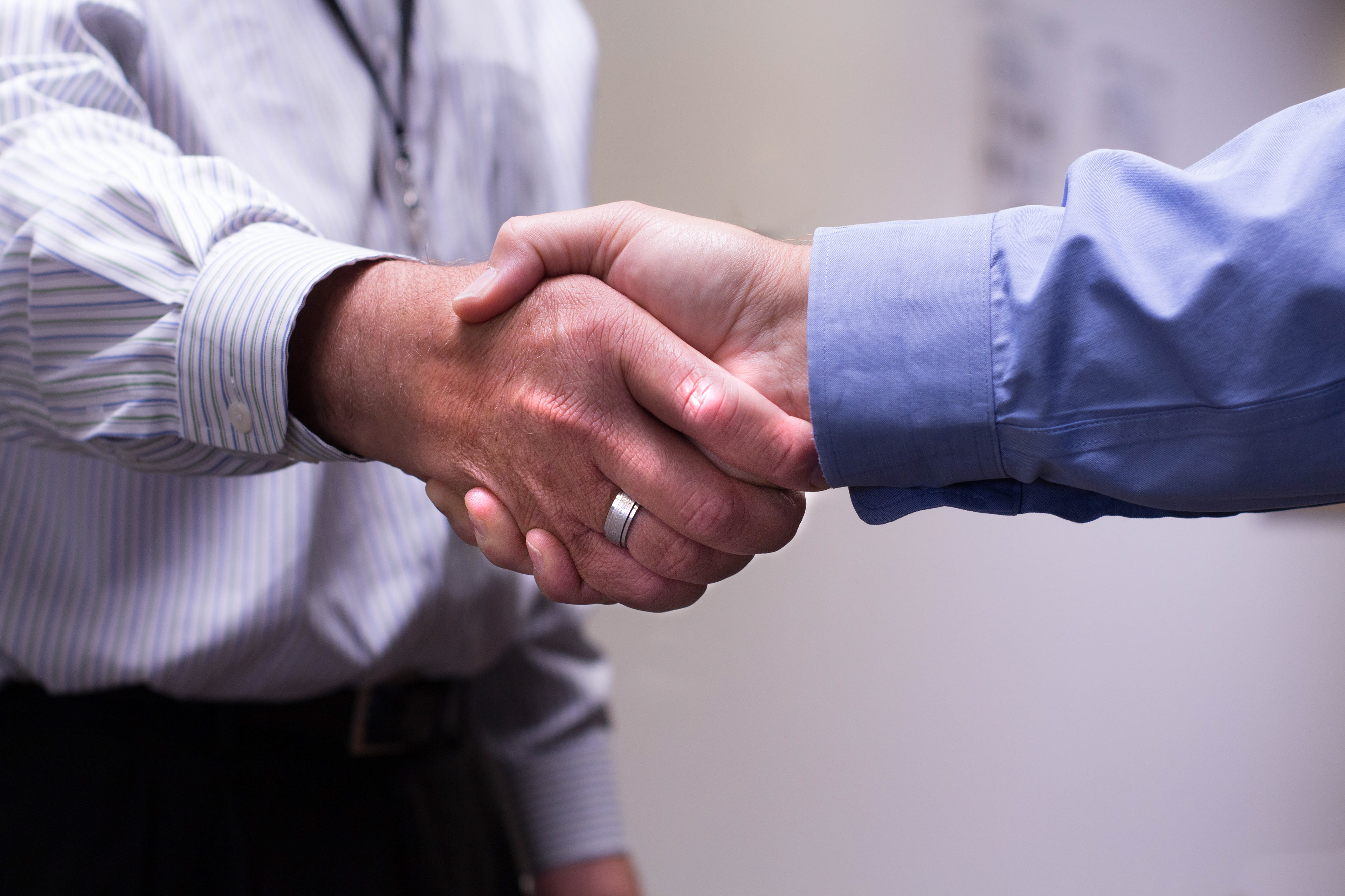 two men shaking hands in an office 