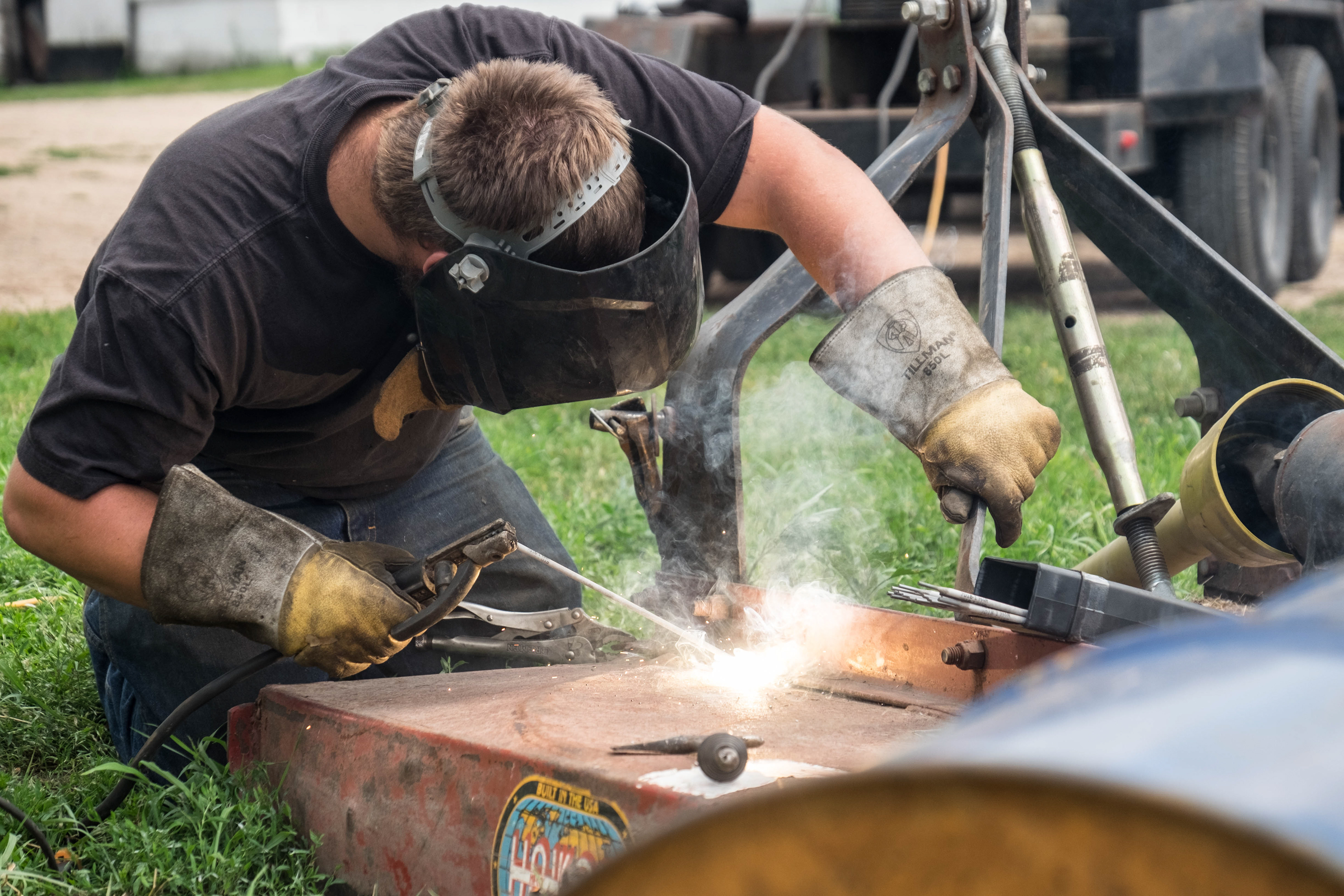 man welding farm equipment