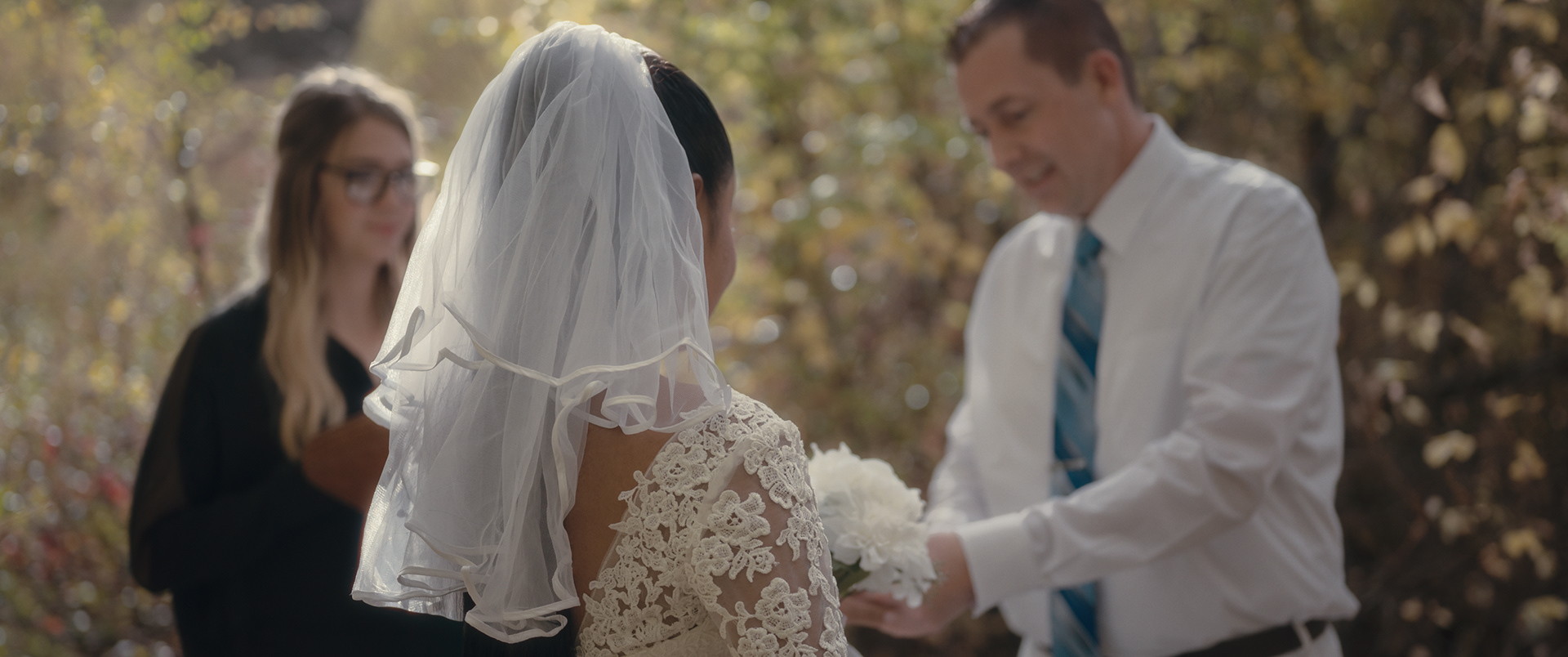 Bride standing with officiant and groom during wedding vows in Pocatello, Idaho.