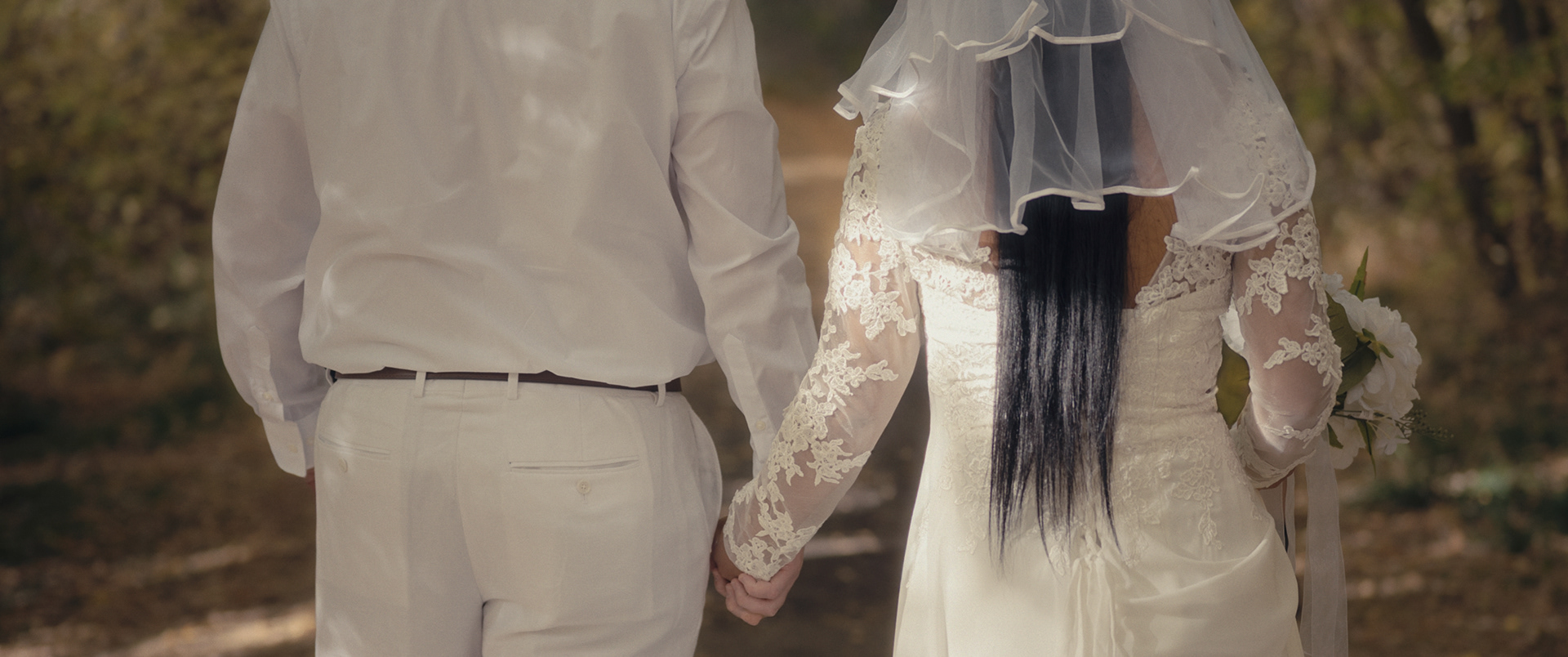 Bride and groom walking through fall trees after their ceremony in Pocatello, Idaho.