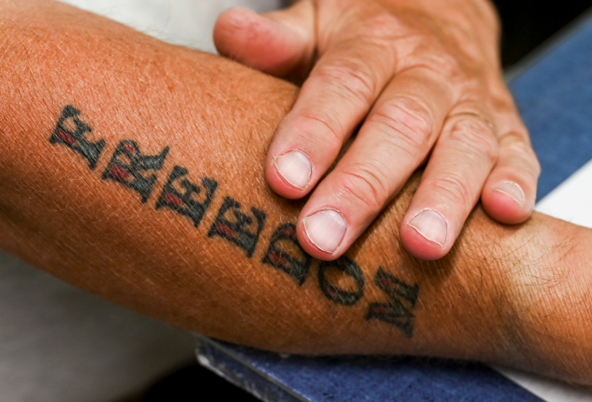 Tom Rayner rubs the tattoo of the word "Freedom" on his arm in The Gun Shop on Rayner's Range, Thursday, September 26, 2024. This tattoo embodies his strong beliefs about liberty and the importance of responsible gun ownership, serving as a personal reminder of the values that drive both his life and his business. For Tom, "Freedom" is not just a word; it symbolizes the deep connection to his family's traditions and the community he nurtures, emphasizing that Rayner's Range is more than a shooting facility, it's a place where passion and purpose come together.
