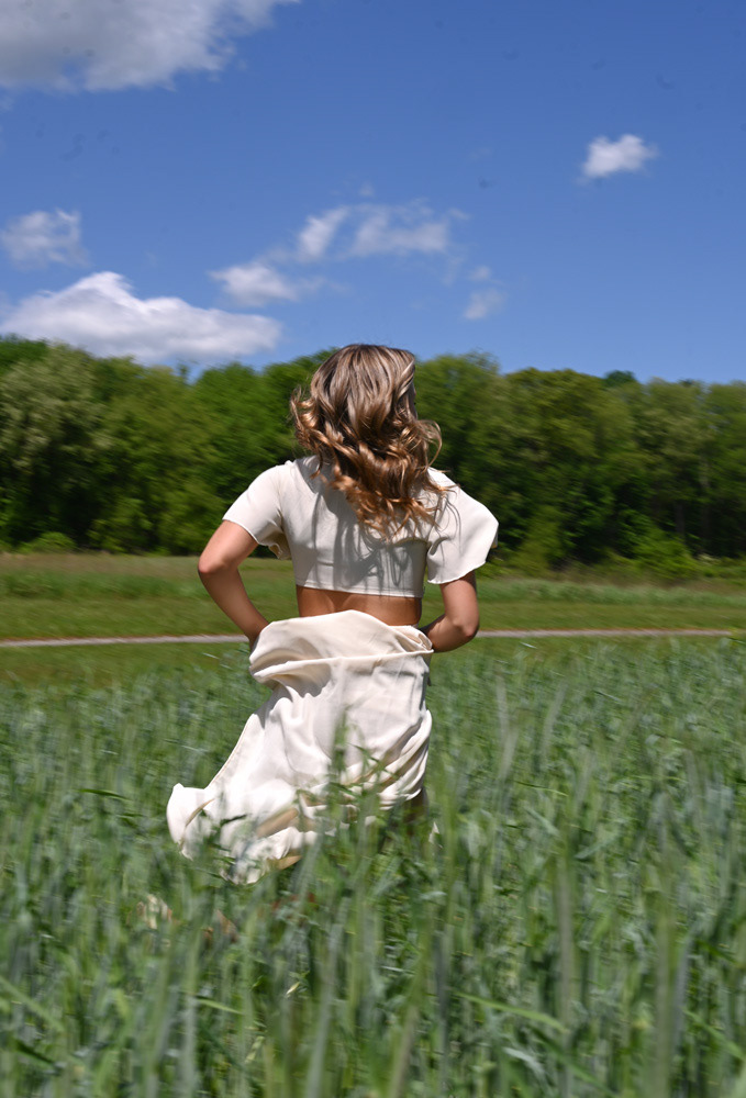 Ava Andrella runs through a field for senior photos at Southgate Farm in Green, Ohio, on Wednesday, May 8, 2024.