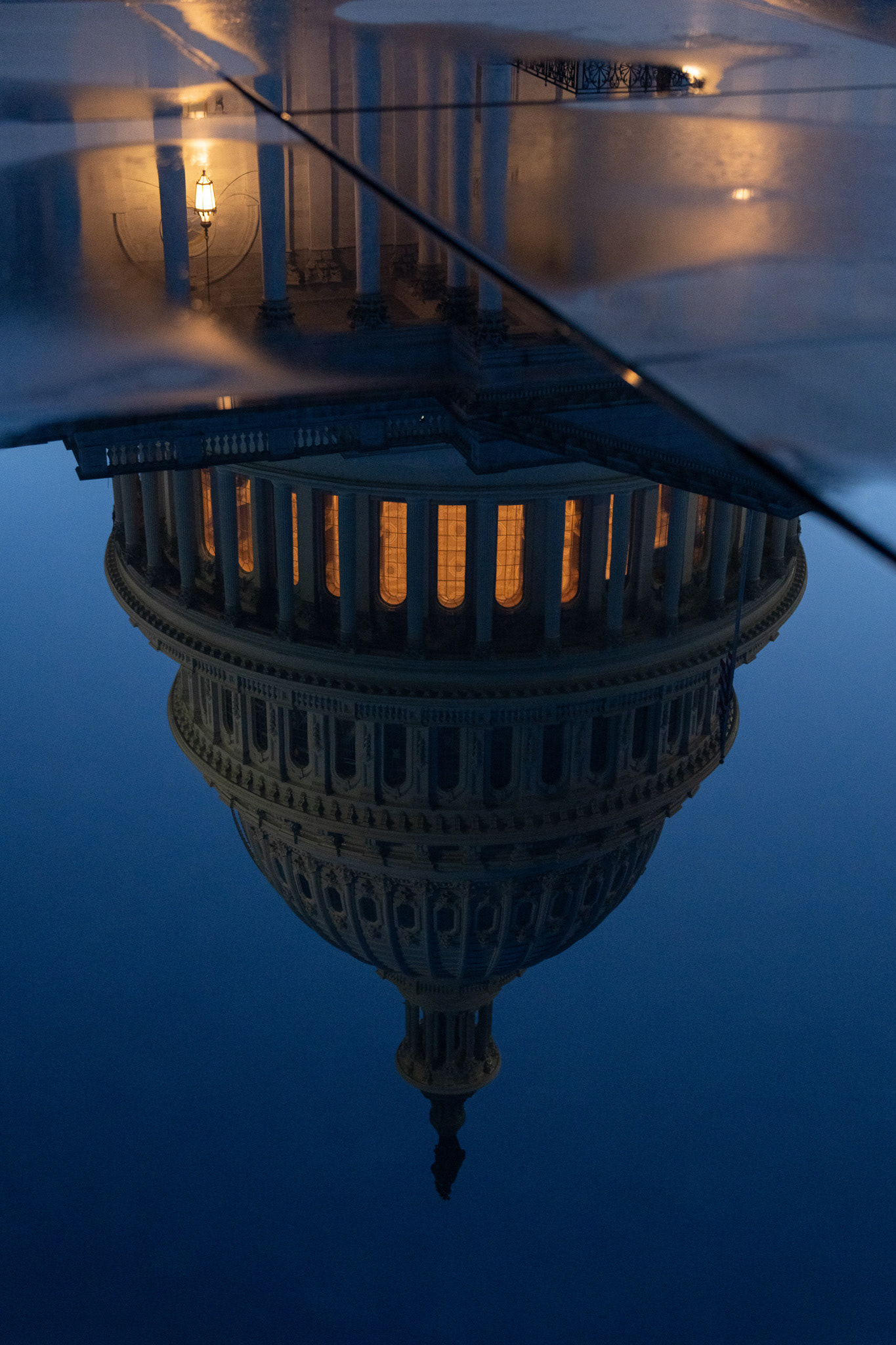 The U.S. Capitol Building reflects in a puddle at sunset in Washington, DC on June 24, 2025.