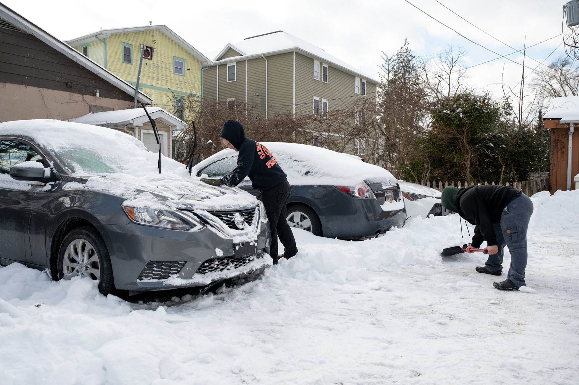 Olivia Rose (left) and her roommate, Melanie Kyriacou (right), shovel their college house driveway in Athens, Ohio, on Tuesday, Jan. 27, 2026. After days of being snowed in, the roommates returned outside to dig their cars out so they could run errands and get to work, as heavy snowfall from the storm had repeatedly blocked their vehicles. The storm disrupted Rose's routine and movement, so going outside became more about taking care of what needed to get done.