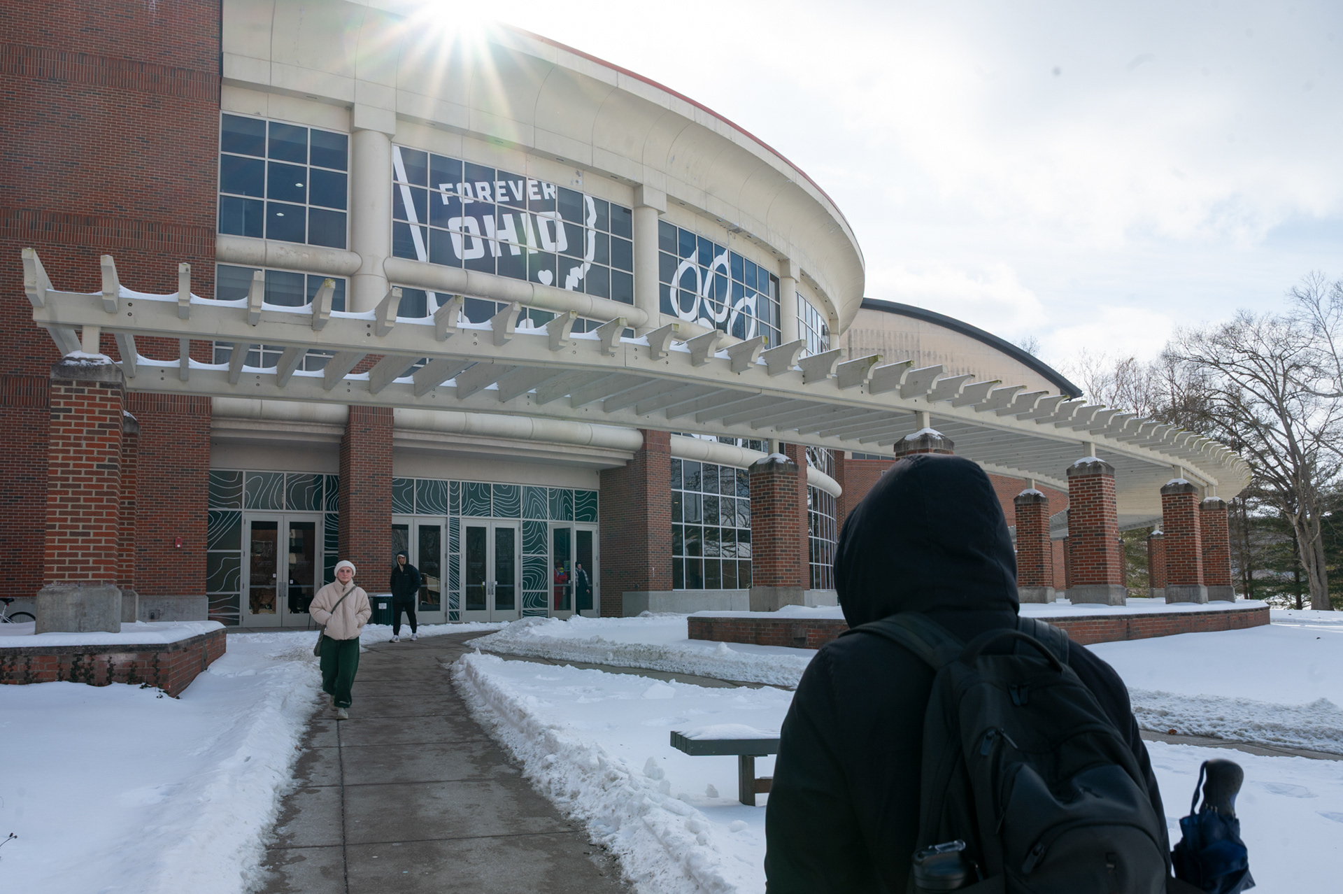 Emma Patsilevas (right), an upperclassman, walks toward the Charles J. Ping Recreation Center at Ohio University on Wednesday, Jan. 28, 2026. After days cooped up at home and completing her first class of the day online instead of in person, Patsilevas turned to the gym as an outlet for movement and motivation. With sidewalks still hazardous but manageable near her home, she limited her trips outside to necessary and recreational activities during the storm.