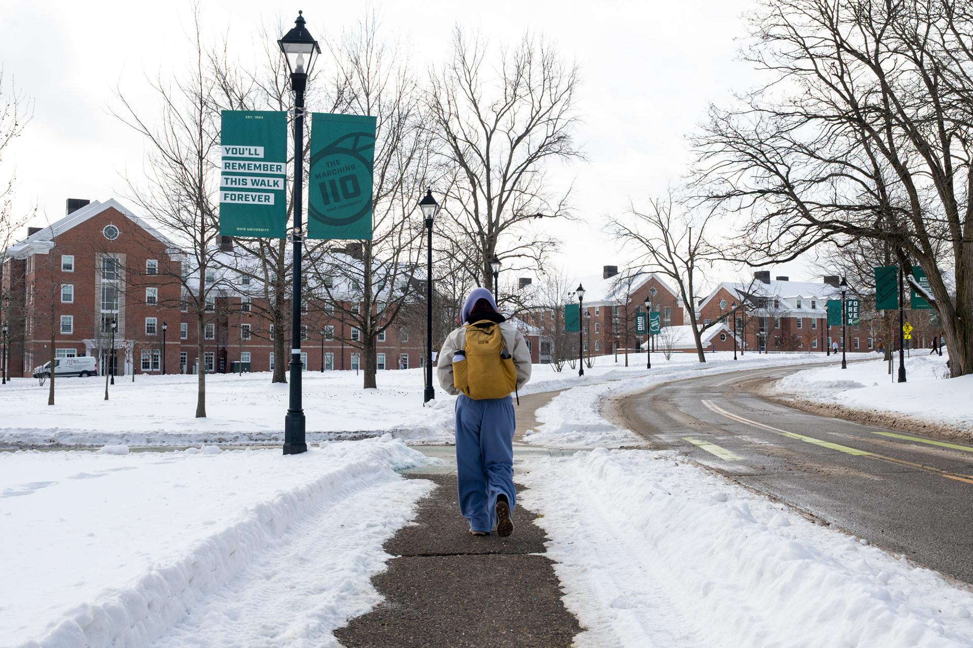 Magdalena Collier, a senior, walks across campus to Clippinger Laboratories at Ohio University on Wednesday, Jan. 28, 2026. After spending much of the storm indoors with her six roommates, playing games and sledding, Collier decided to brave the cold so she could focus on completing lab assignments that had been inaccessible earlier due to the snow. Wearing extra layers to avoid frostbite, she navigated mostly cleared campus sidewalks while taking extra caution near off-campus areas, where walkways remained poorly maintained.