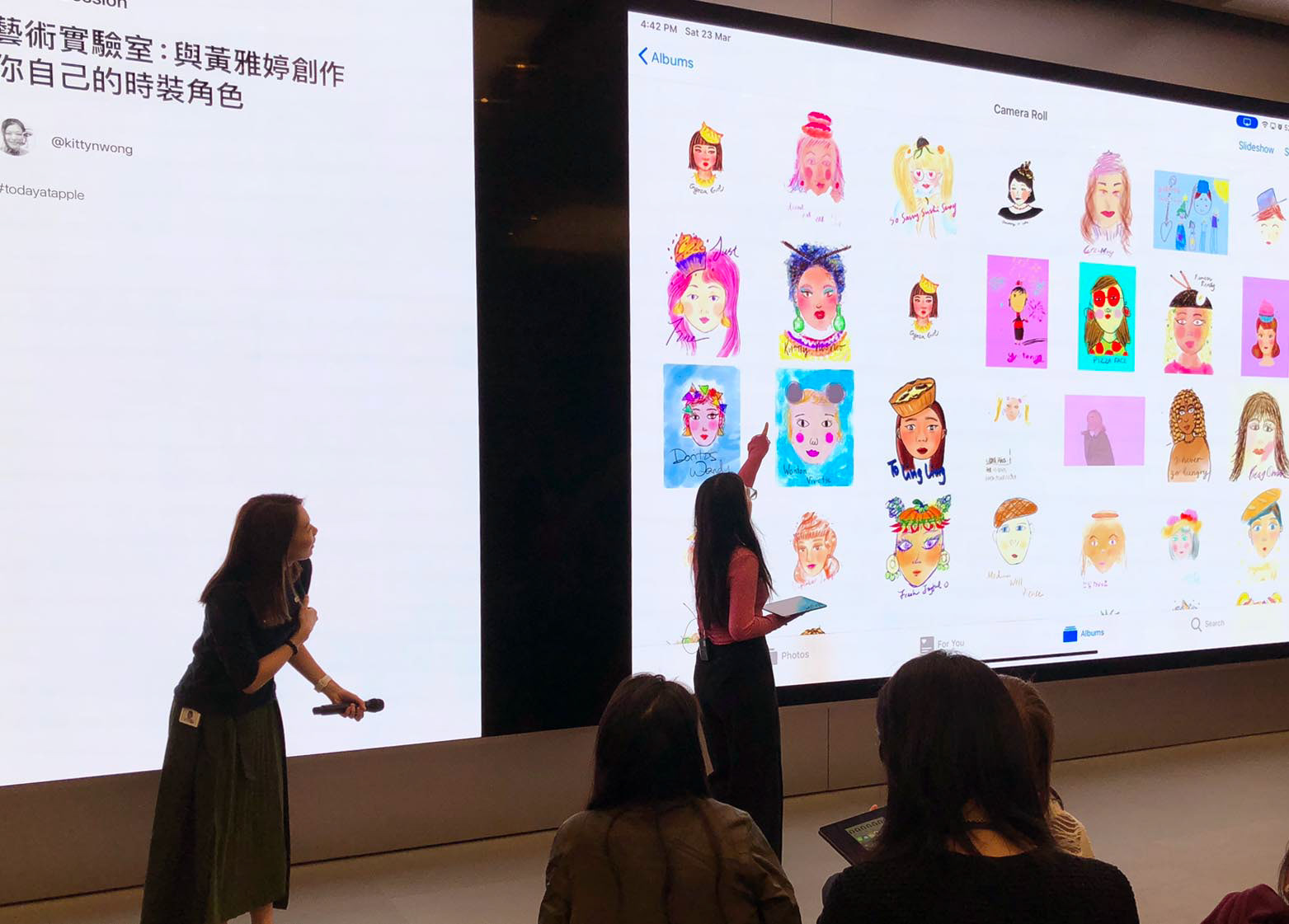 Hong Kong female illustrator pointing to student’s artwork on large wall at Apple store in Causeway Bay
