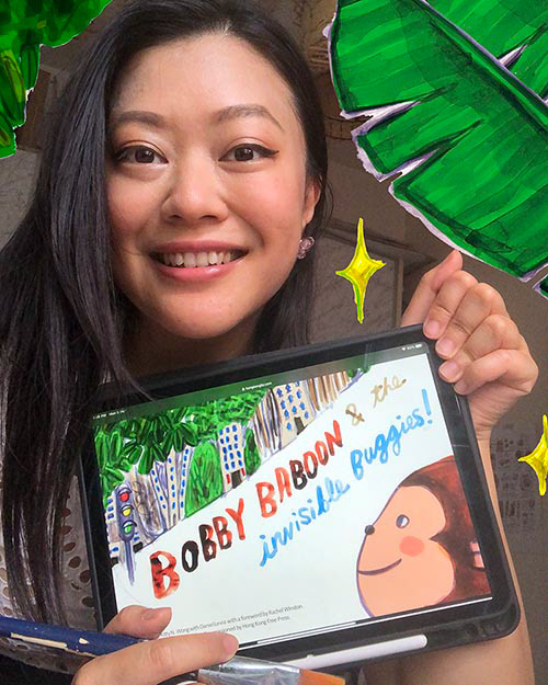 Young Chinese woman holding children’s ebook on Ipad that says "Bobby Baboon" with green leaves next to her