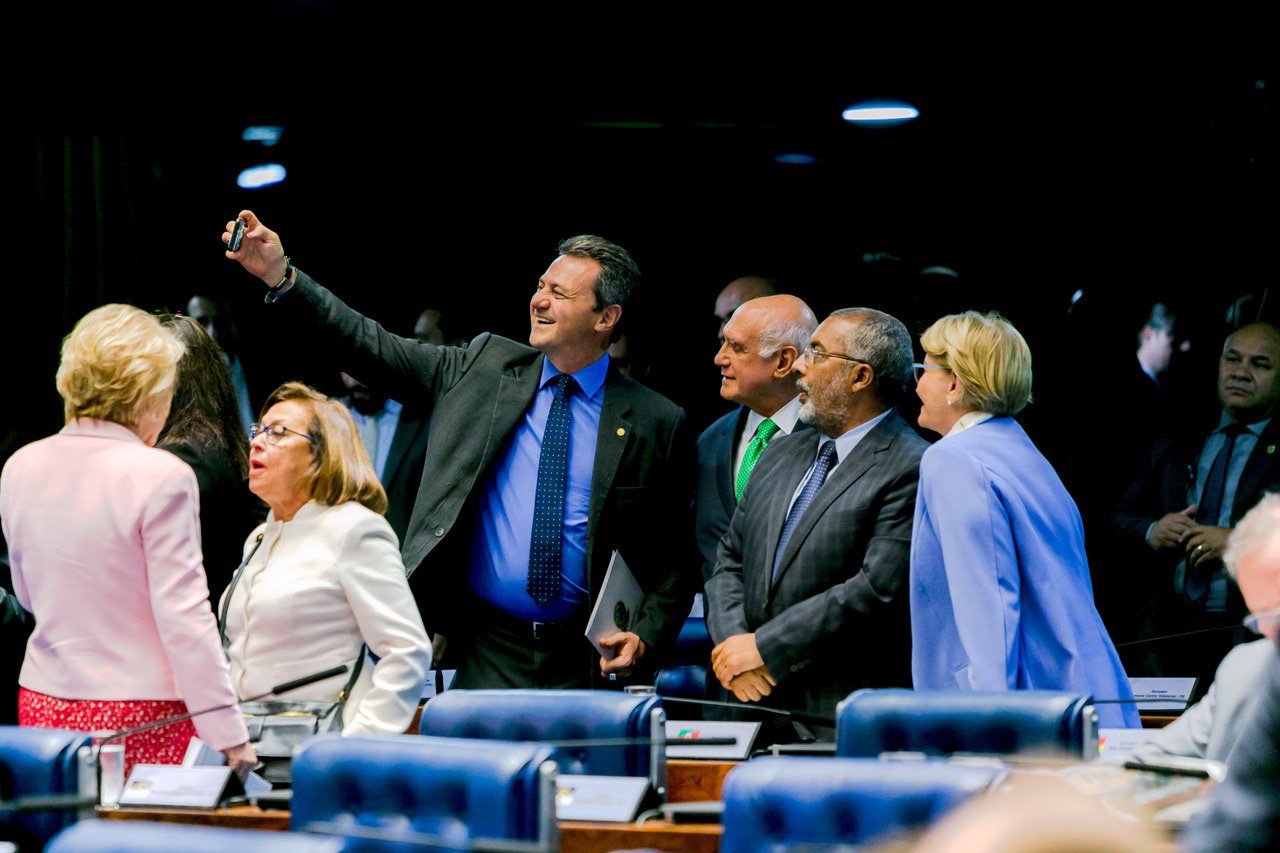 Interação entre parlamentares em momento de articulação no plenário.