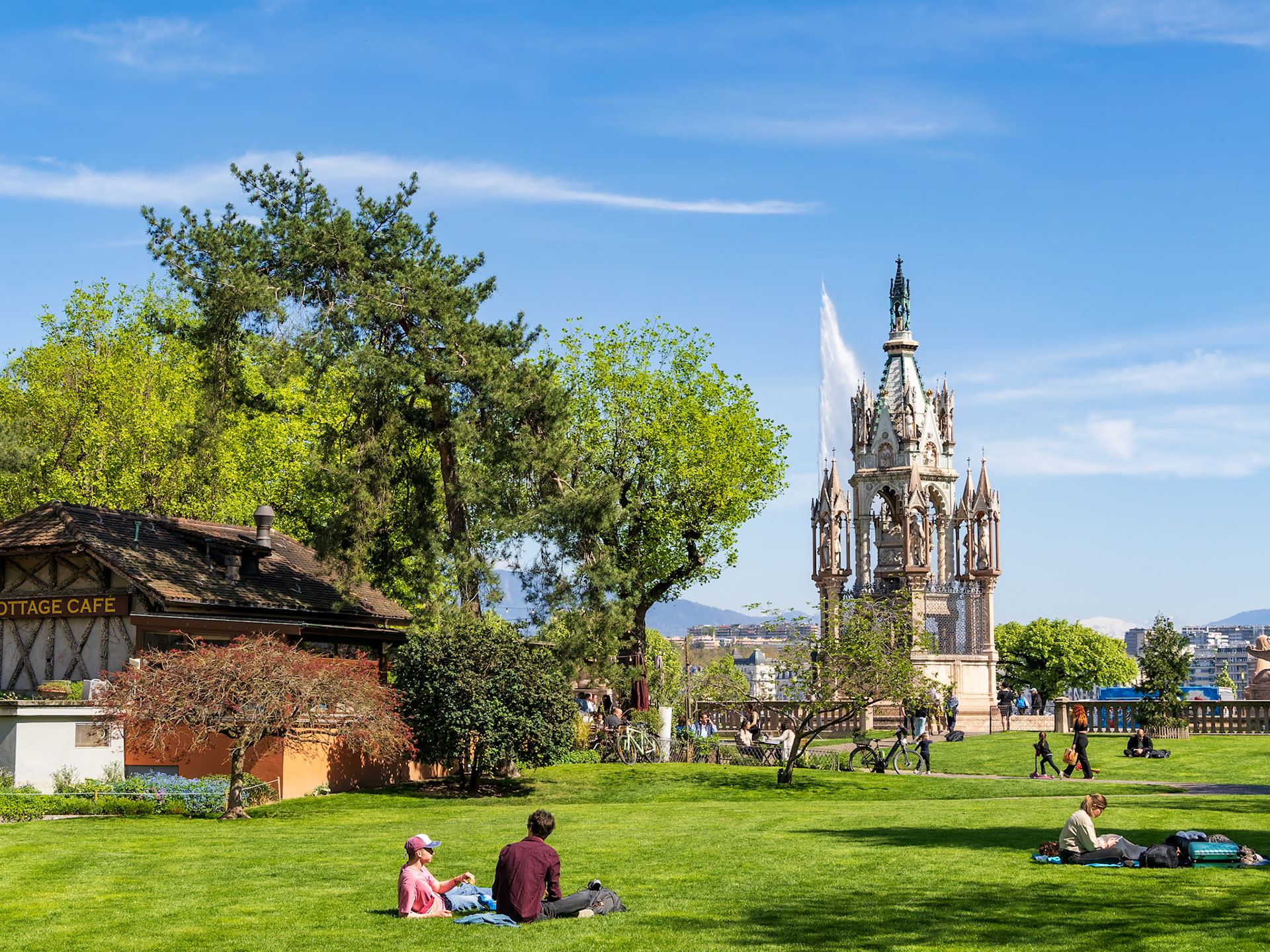 Square des Alpes park and the Brunswick Monument - a Landmark Neo-Gothic monument in honor of 19th-century duke. Behind the monument is the Jet d'Eau - the Geneva Water Fountain.