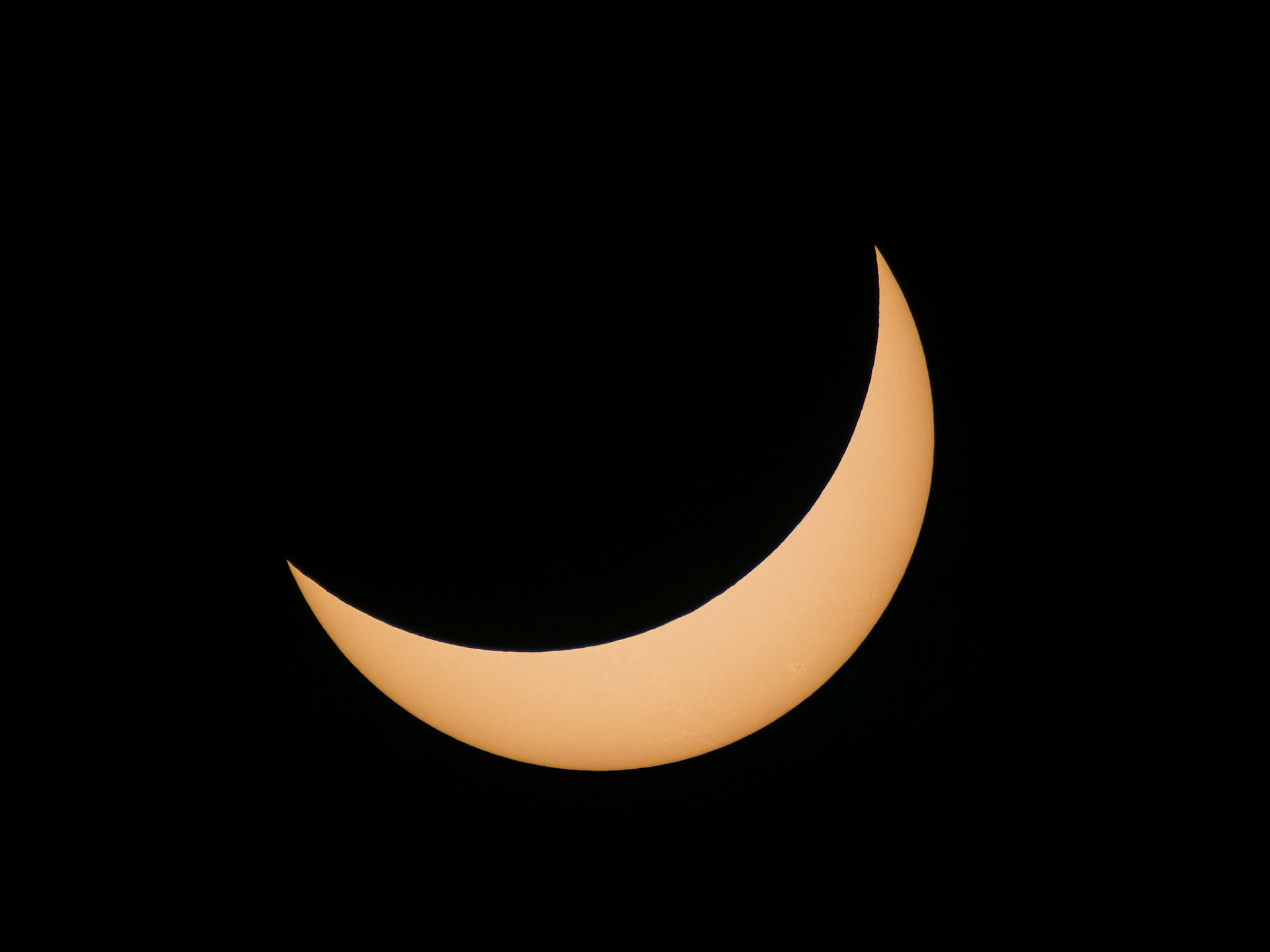 Moon slowly reveals the sun again. Sunspots are visible in this part near the bottom.