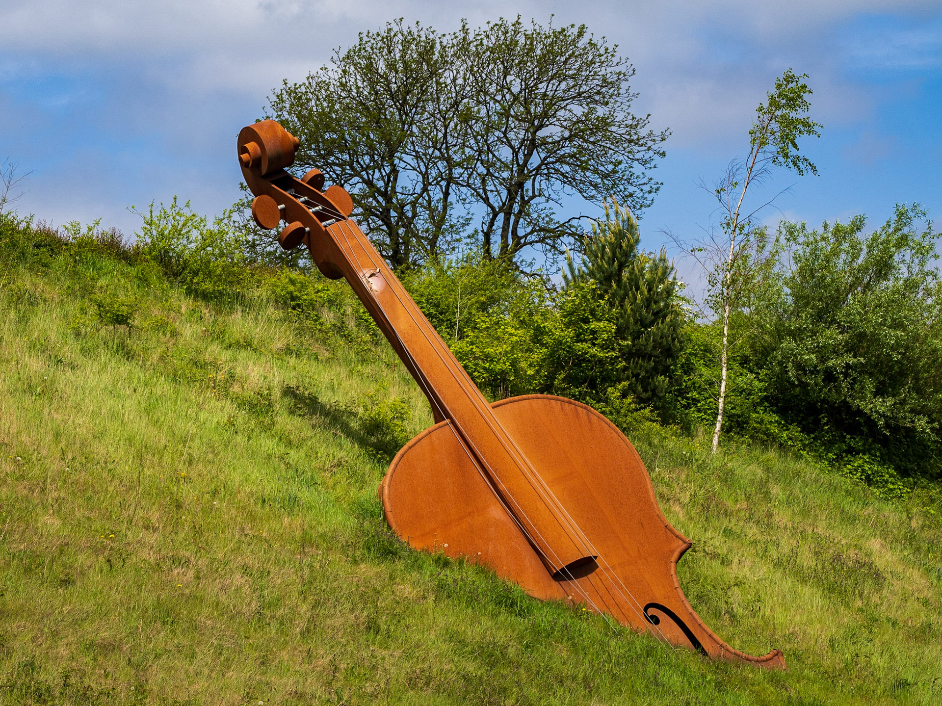 The steel sculpture on the N5 Bypass outside Longford Town by Alex Pentek represents the upper portion of a giant 20m long violin as if it has been partly unearthed by the newly cut-away embankment. Using a bold, elegant, yet simple visual language this idea aims to communicate Longford’s rich musical heritage as both an expression and as part of the surrounding landscape.