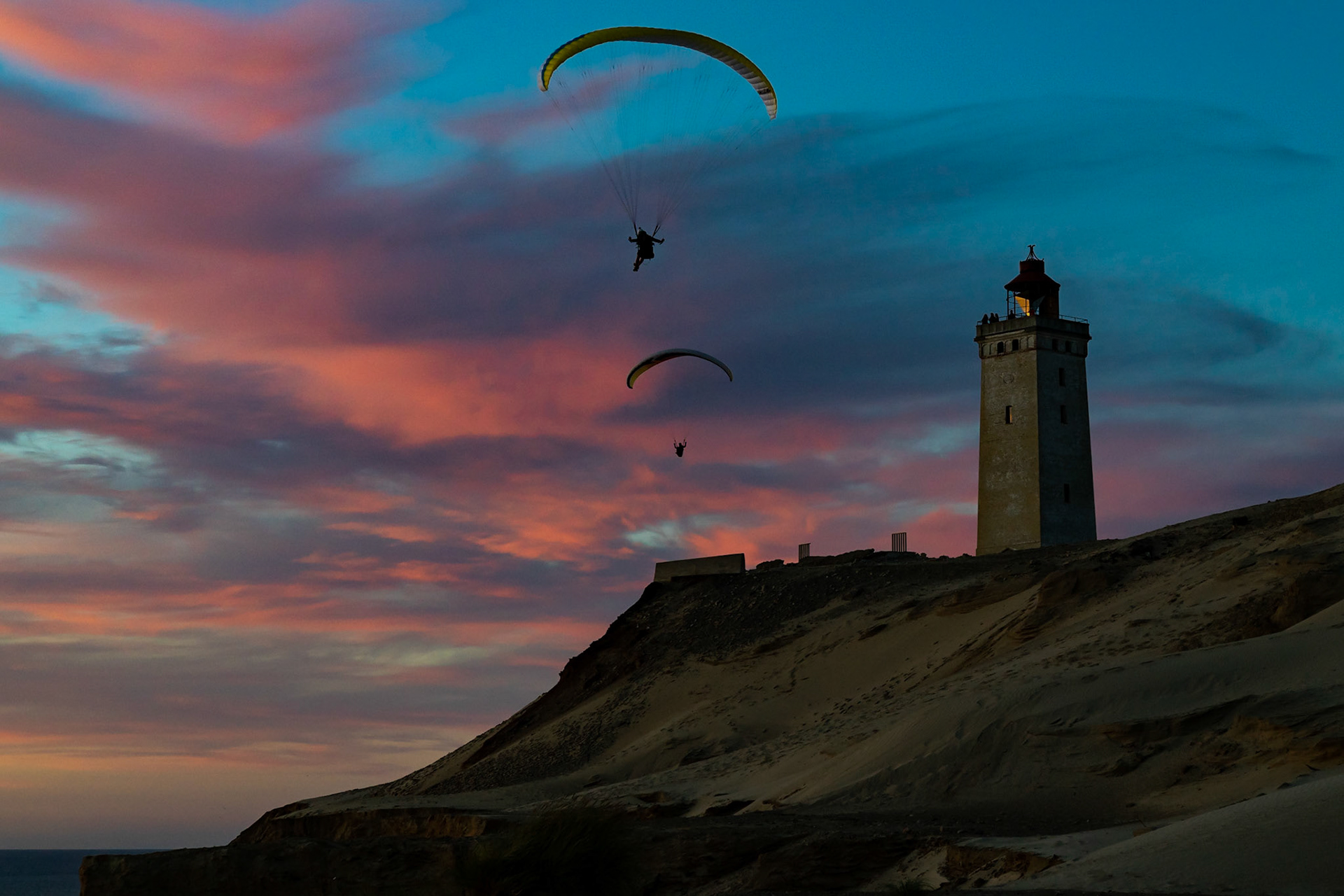 Paragliders soaring near Rubjerg Knude Fyr in Denmark