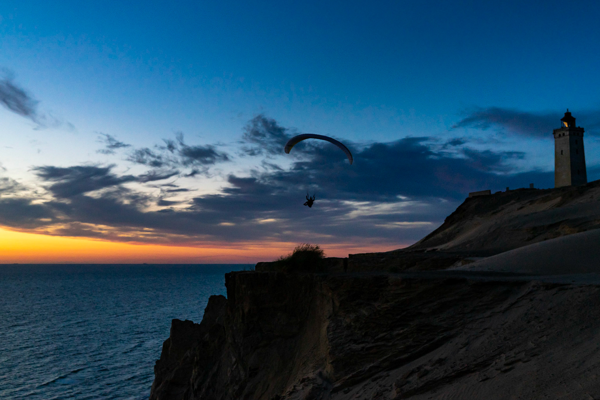 Paragliders soaring into the amazing sunset near Lokken Denmark